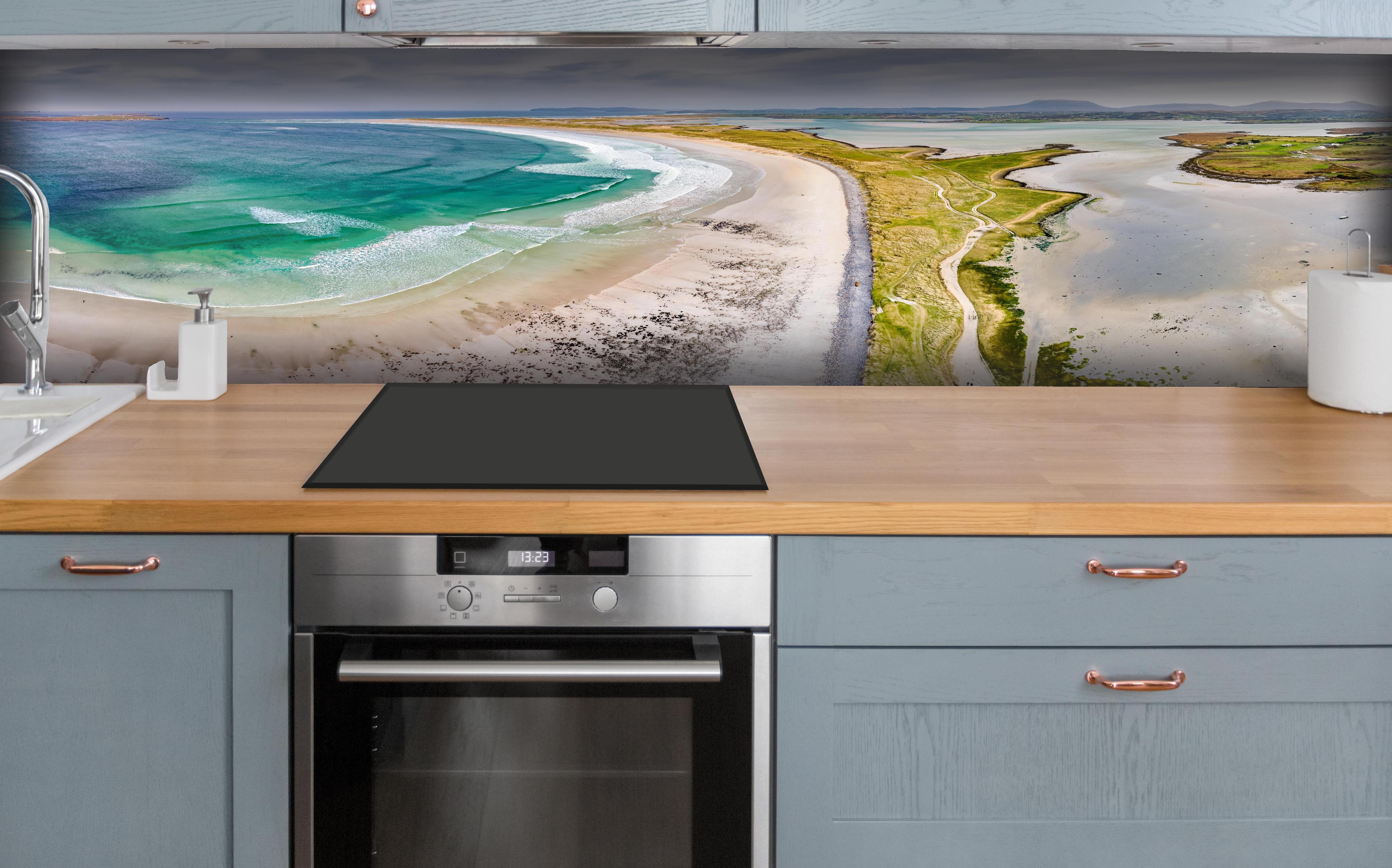 Küche - Luftaufnahme der Küste von Magheraroarty-Irland hinter weißen Hochglanz-Küchenregalen und schwarzem Wasserhahn