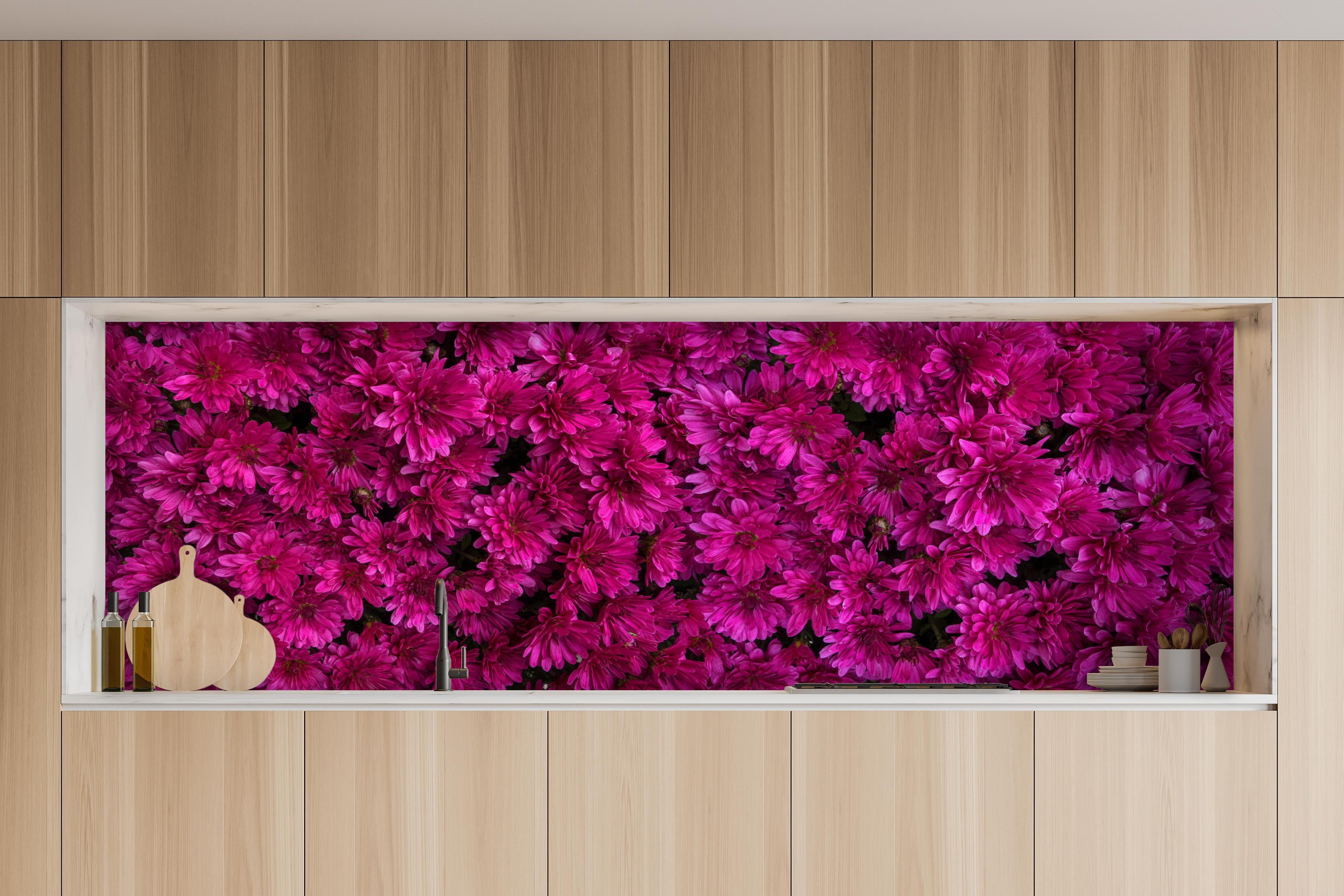 Küche - Magenta Blüten von Chrysanthemen hinter weißen Hochglanz-Küchenregalen und schwarzem Wasserhahn