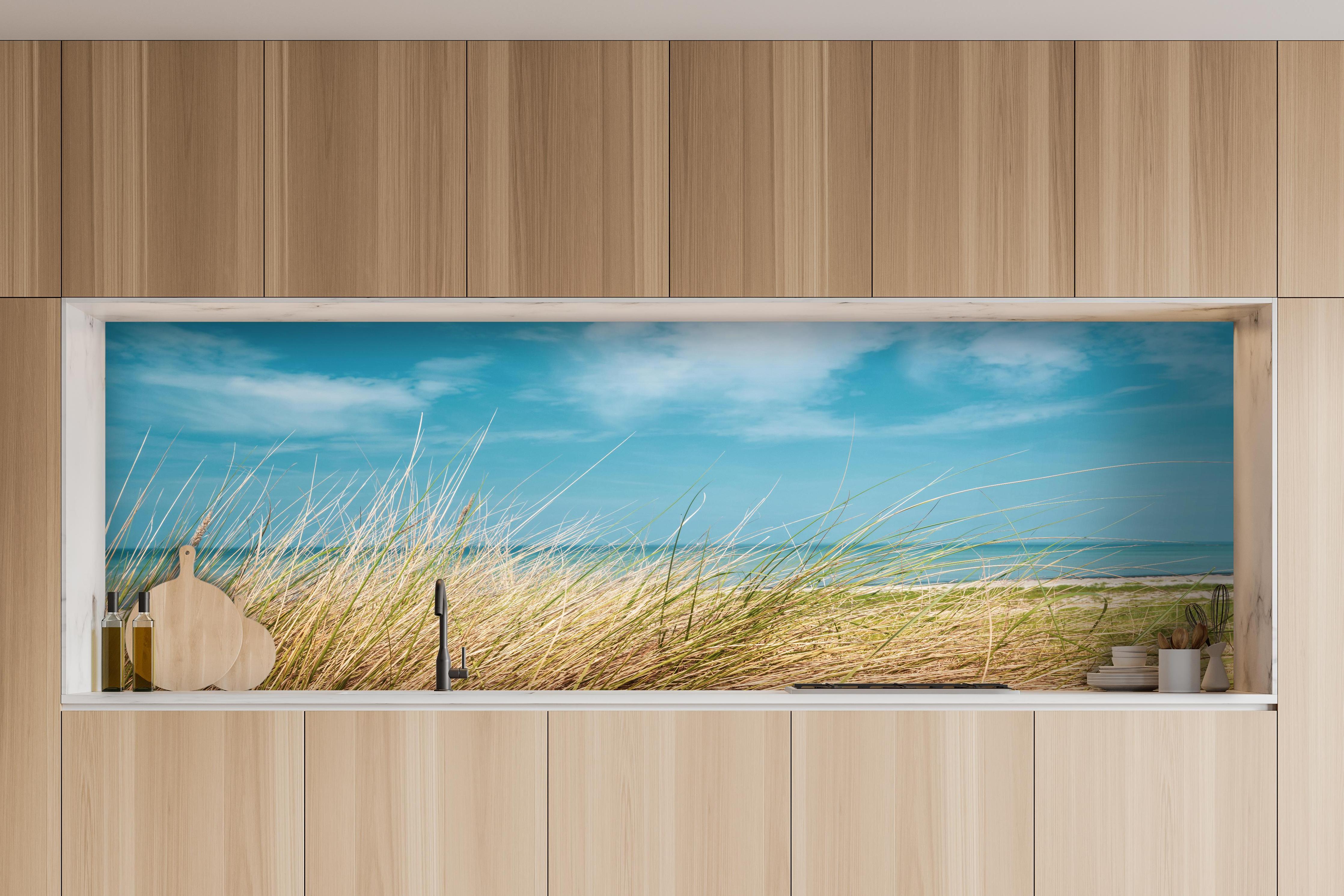 Küche - Malersicher Küstenabschnitt mit goldenem Gras und türkisem Himmel hinter weißen Hochglanz-Küchenregalen und schwarzem Wasserhahn