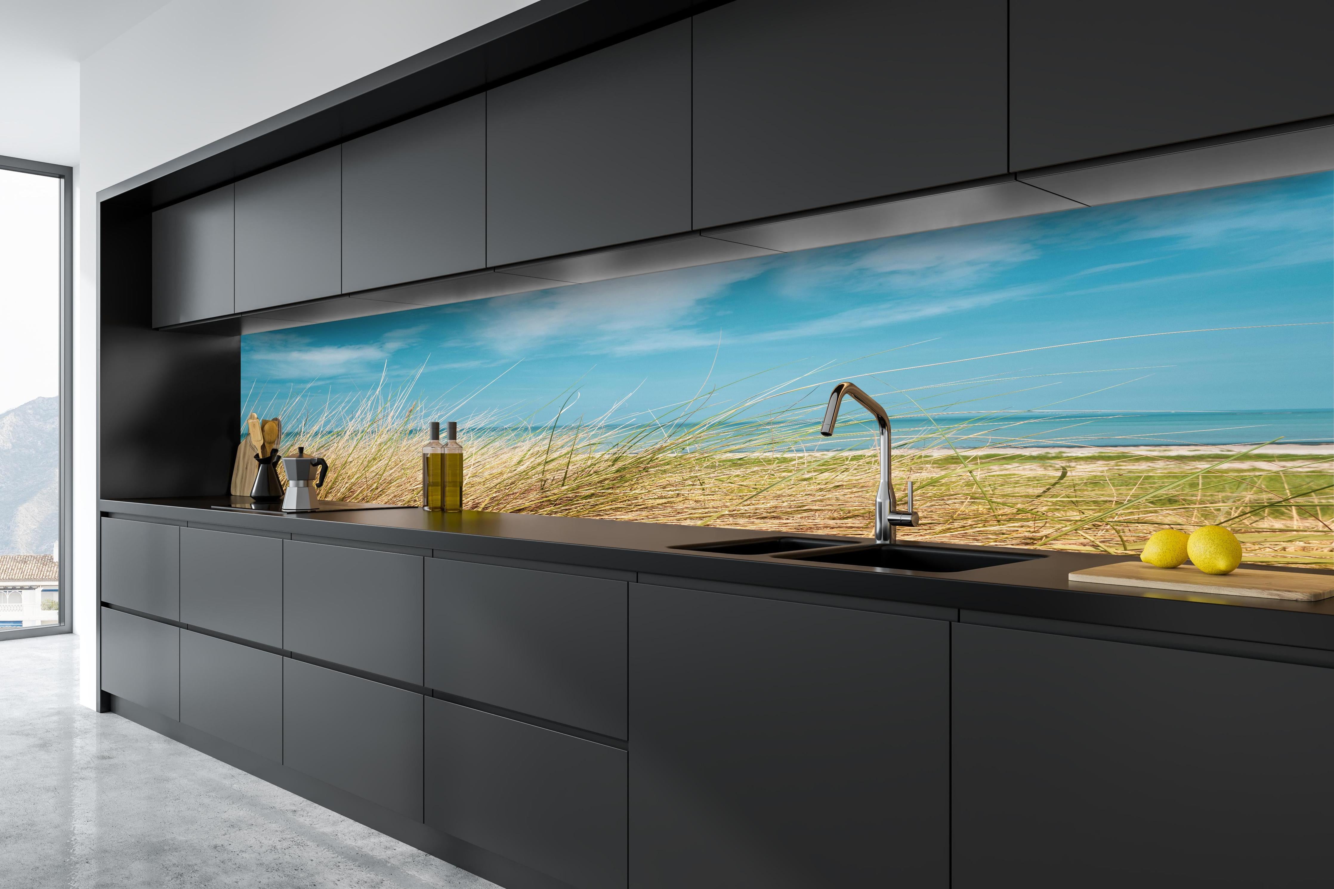 Küche - Malersicher Küstenabschnitt mit goldenem Gras und türkisem Himmel hinter weißen Hochglanz-Küchenregalen und schwarzem Wasserhahn