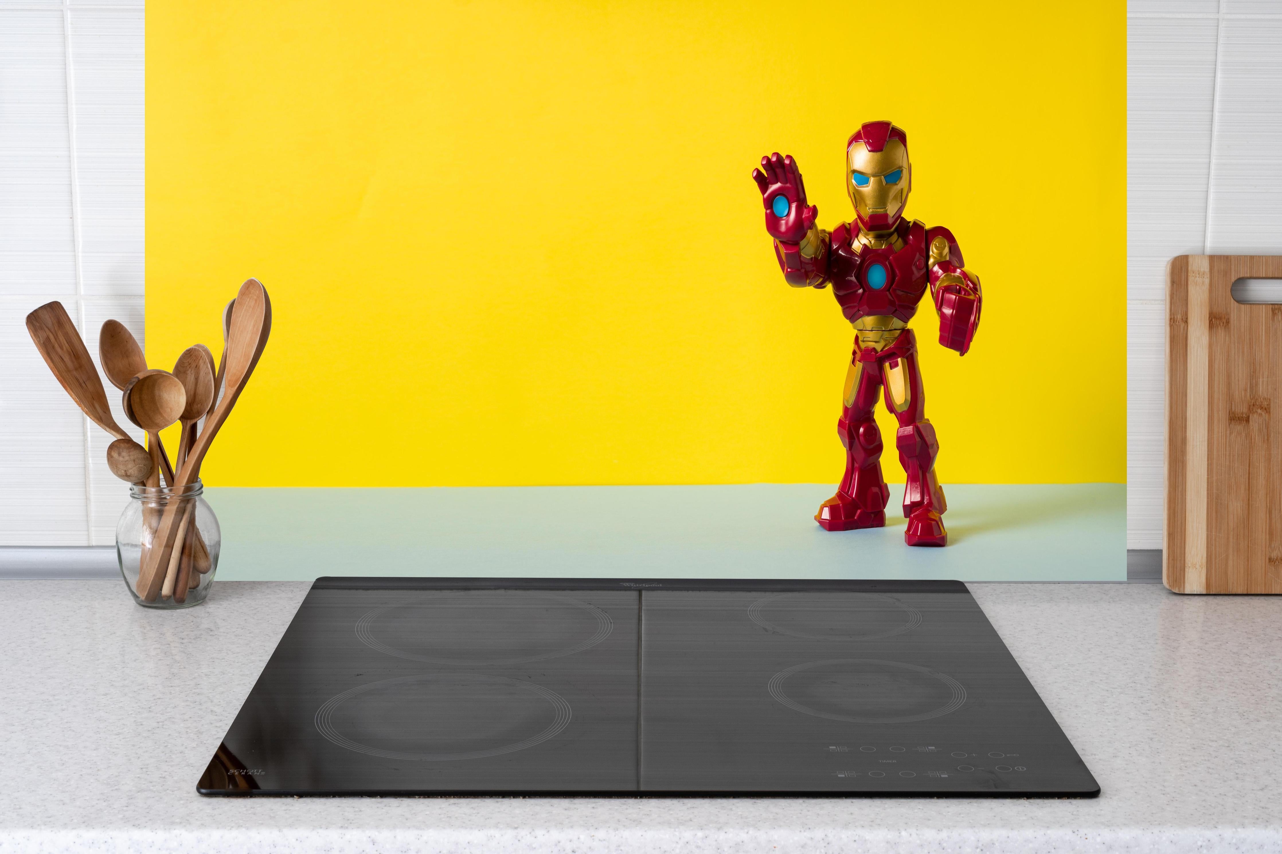 Küche - Marvel Iron Man Sammelfigur auf Gelb hinter weißen Hochglanz-Küchenregalen und schwarzem Wasserhahn