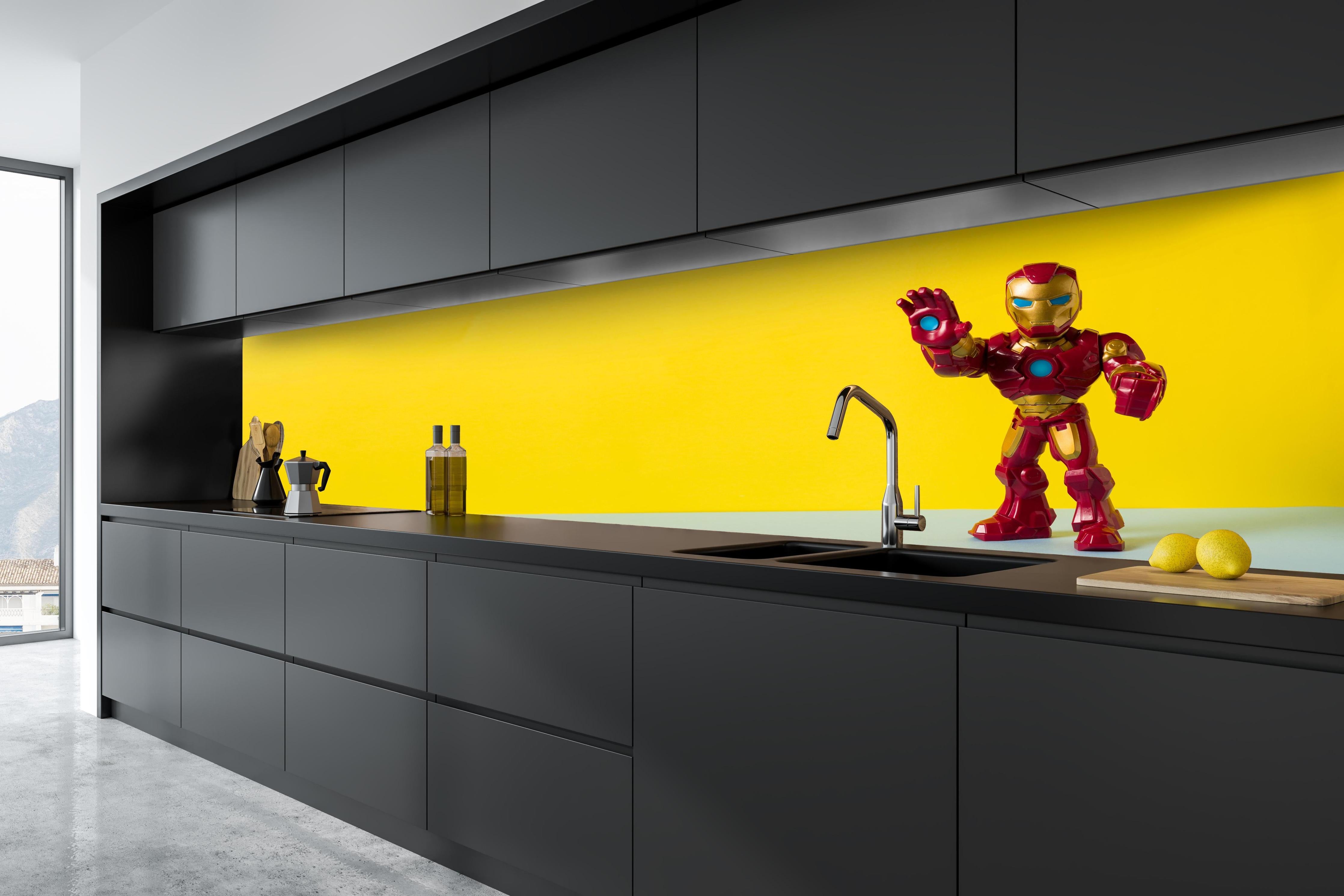 Küche - Marvel Iron Man Sammelfigur auf Gelb hinter weißen Hochglanz-Küchenregalen und schwarzem Wasserhahn