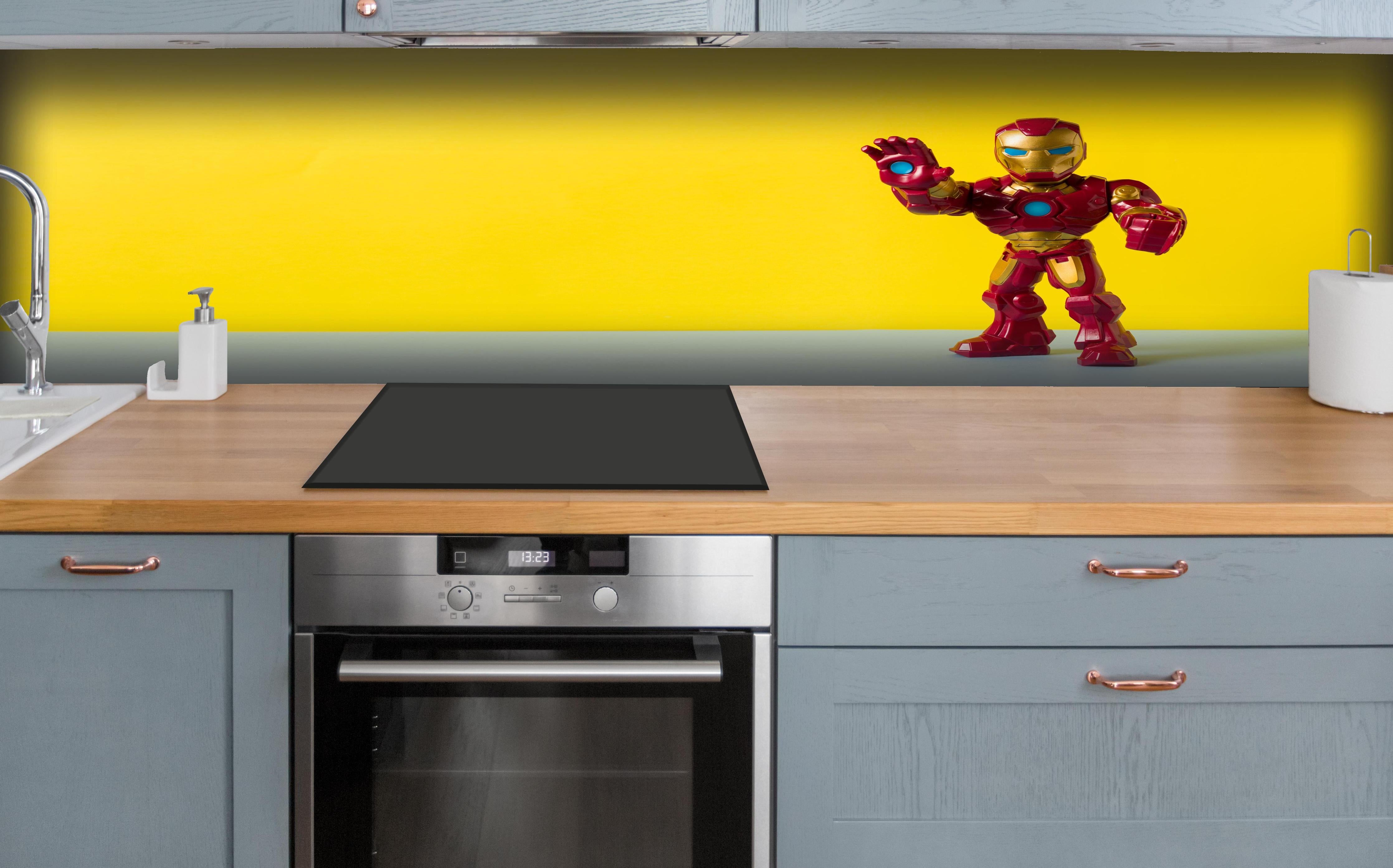 Küche - Marvel Iron Man Sammelfigur auf Gelb hinter weißen Hochglanz-Küchenregalen und schwarzem Wasserhahn