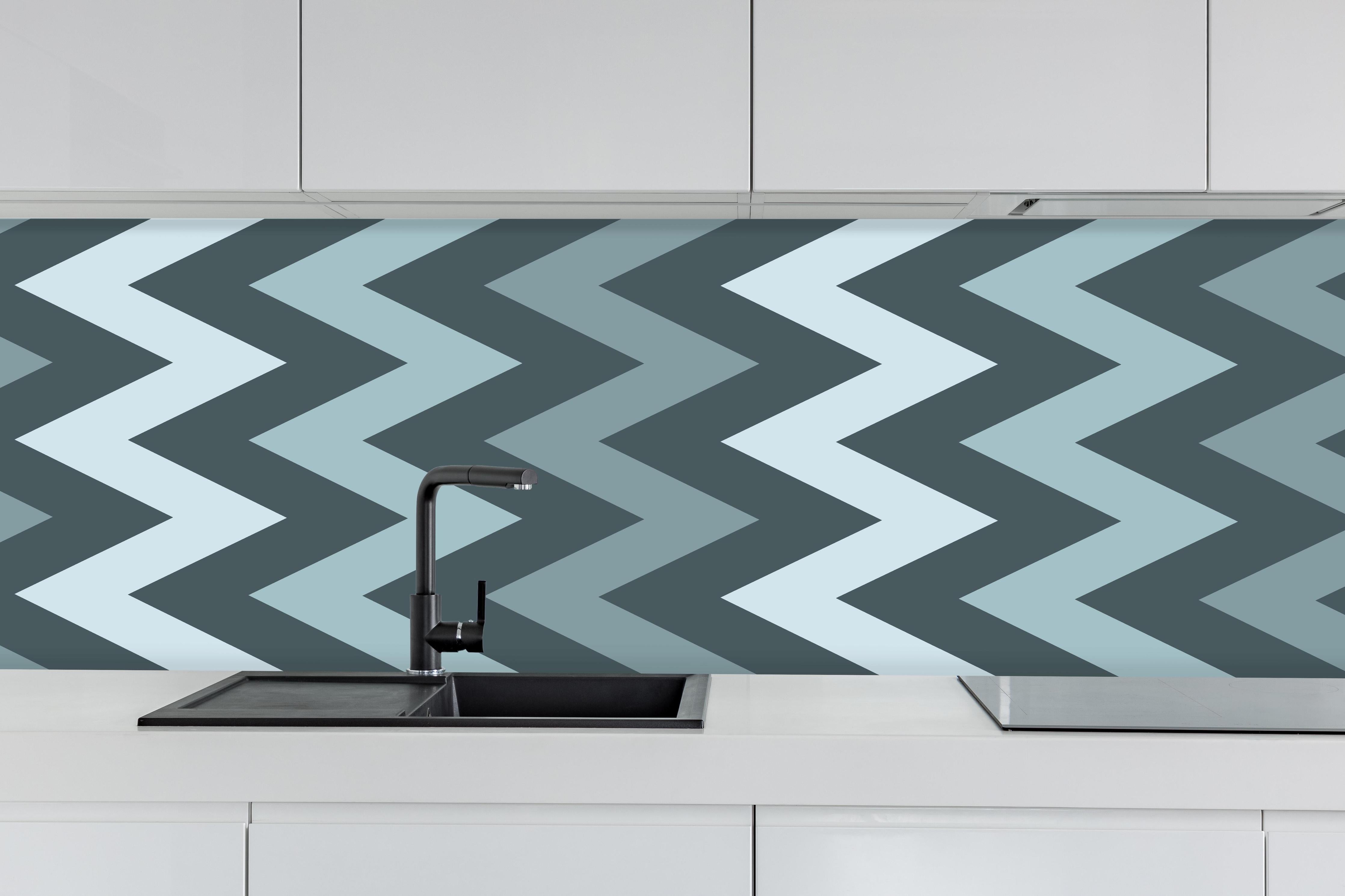 Küche - Modernes Chevron Design in Grau-Weiß hinter weißen Hochglanz-Küchenregalen und schwarzem Wasserhahn