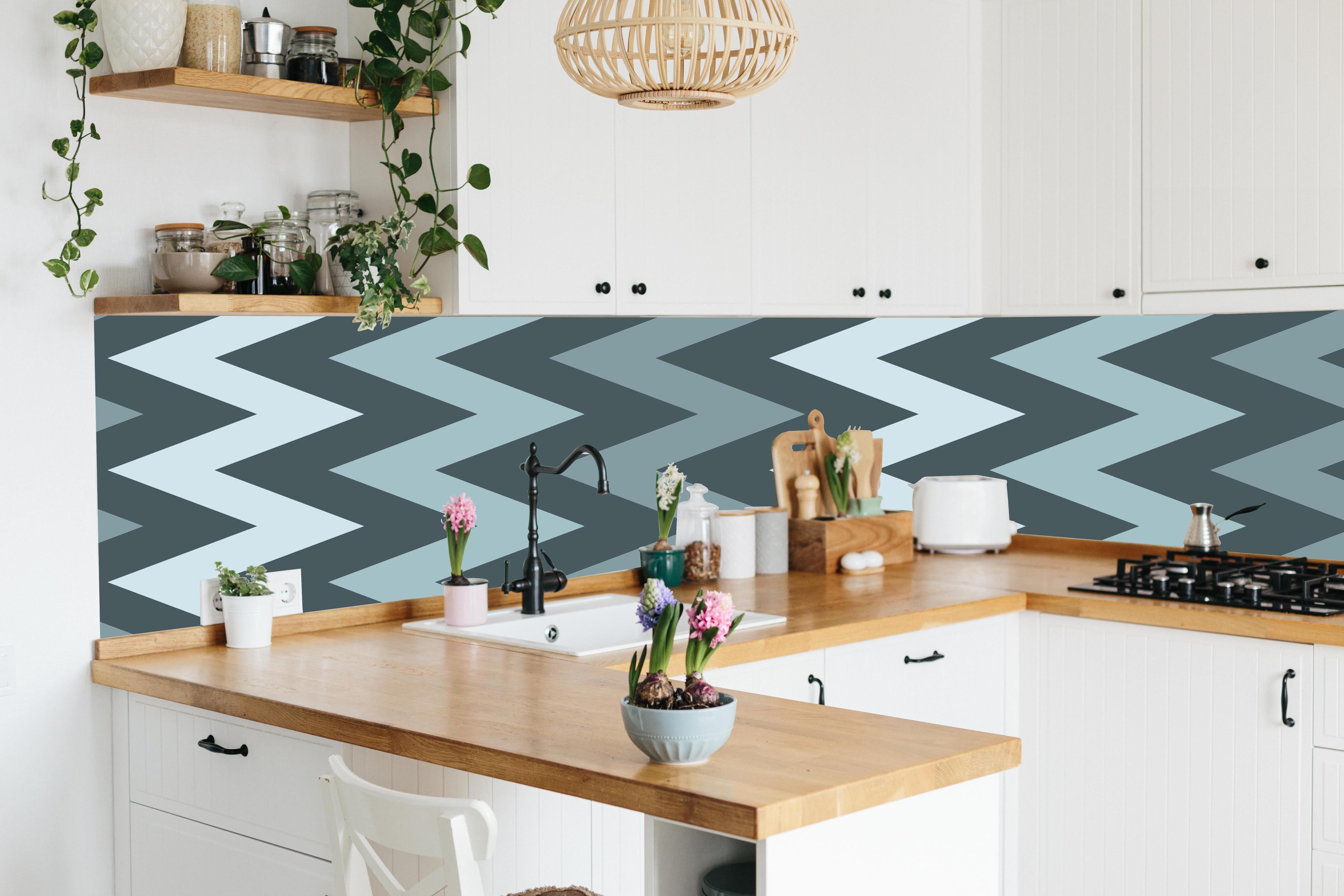Küche - Modernes Chevron Design in Grau-Weiß hinter weißen Hochglanz-Küchenregalen und schwarzem Wasserhahn