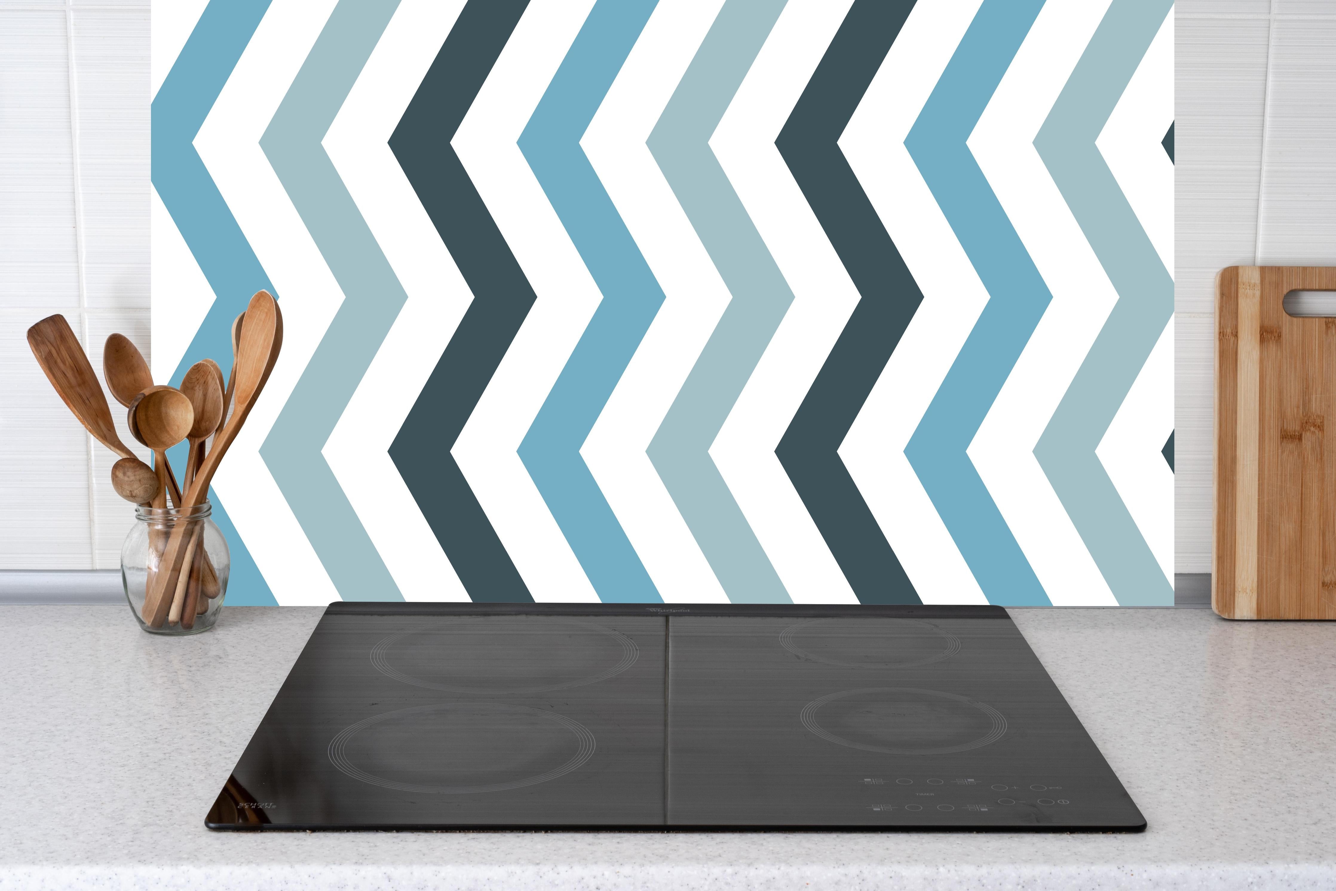 Küche - Modisches Zick-Zack-Muster in Grau und Weiß hinter weißen Hochglanz-Küchenregalen und schwarzem Wasserhahn