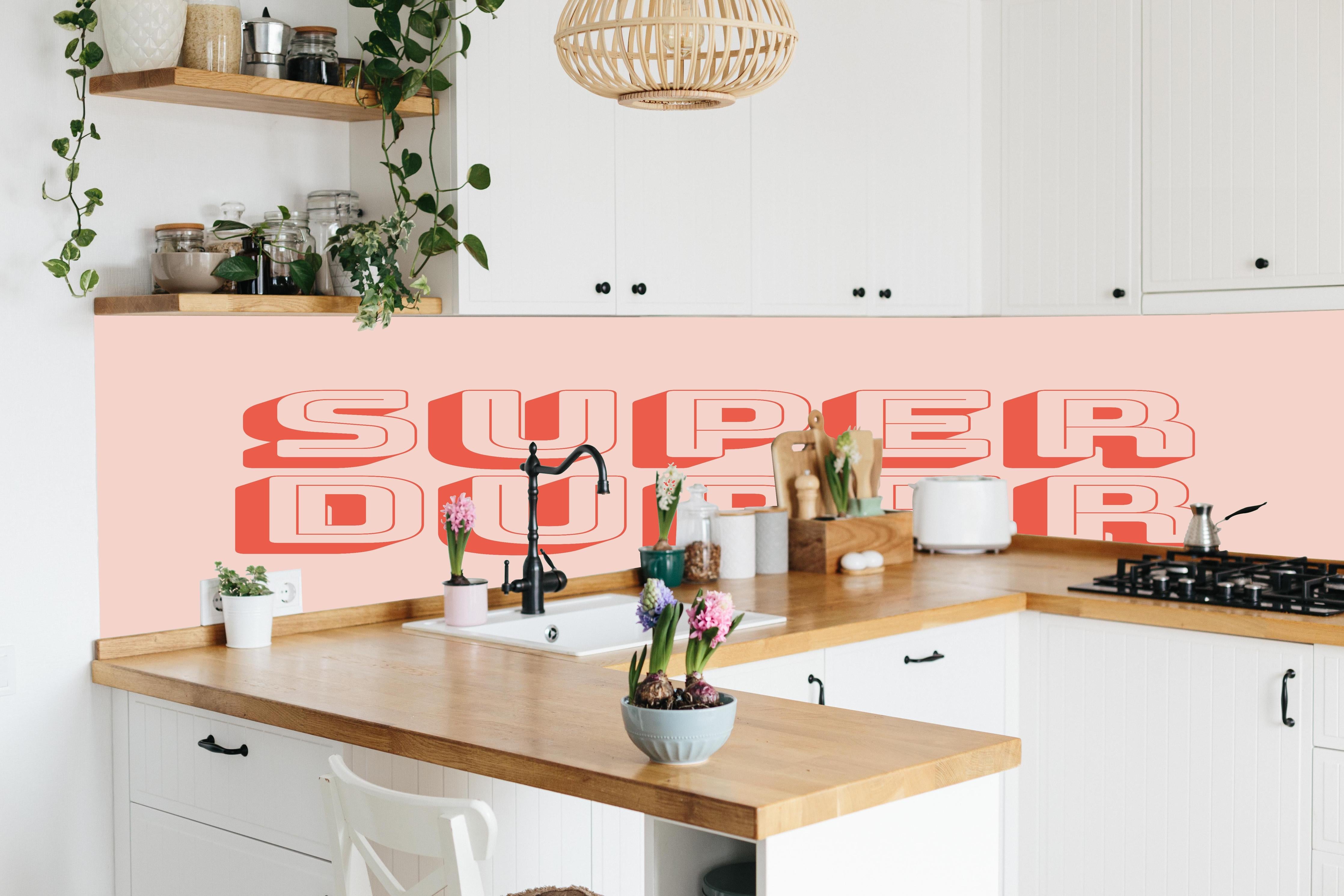 Küche - Motivationaler 'Super Duper' Schriftzug in Pink hinter weißen Hochglanz-Küchenregalen und schwarzem Wasserhahn