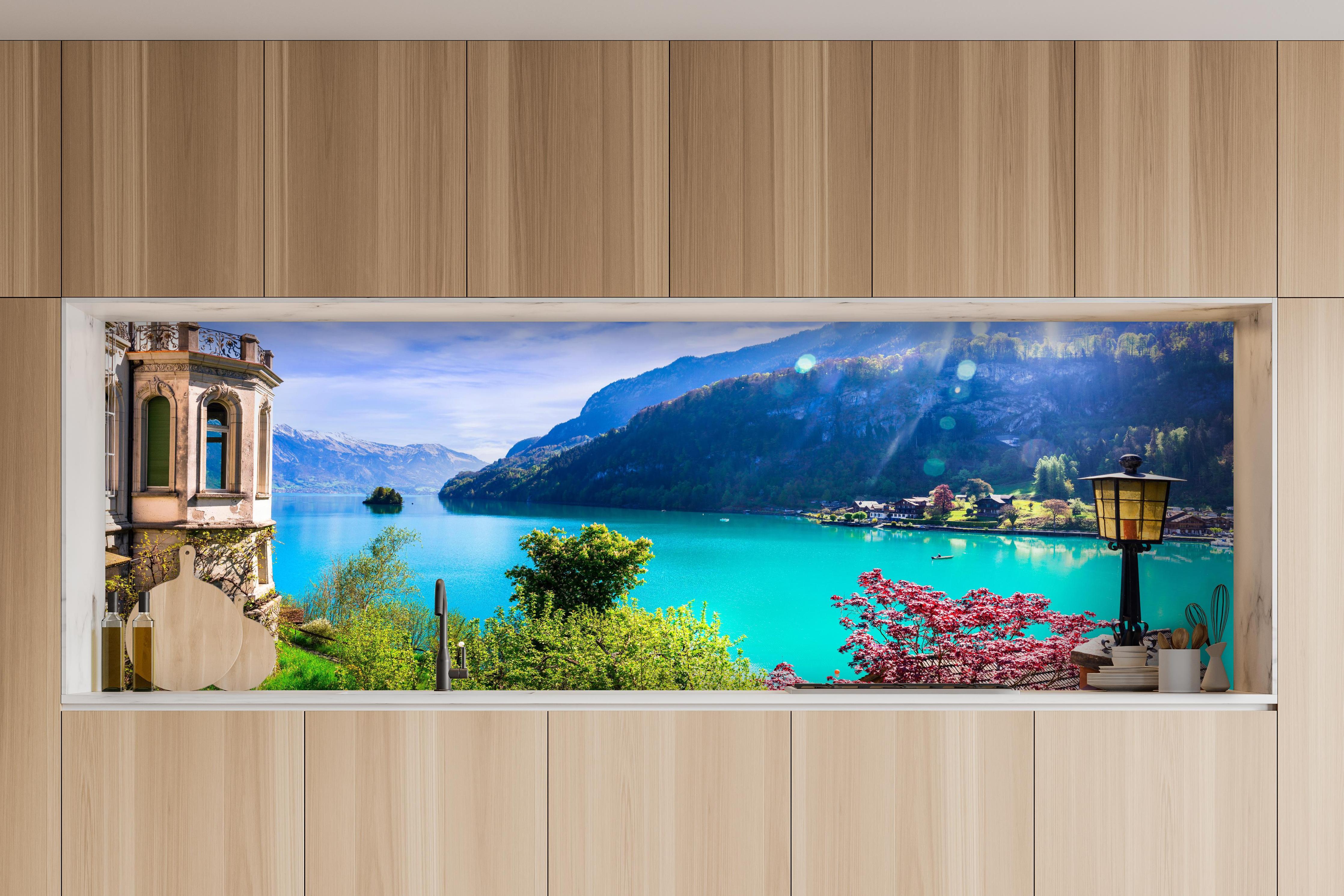 Küche - Naturkulisse des Brienzersees - Schweiz hinter weißen Hochglanz-Küchenregalen und schwarzem Wasserhahn