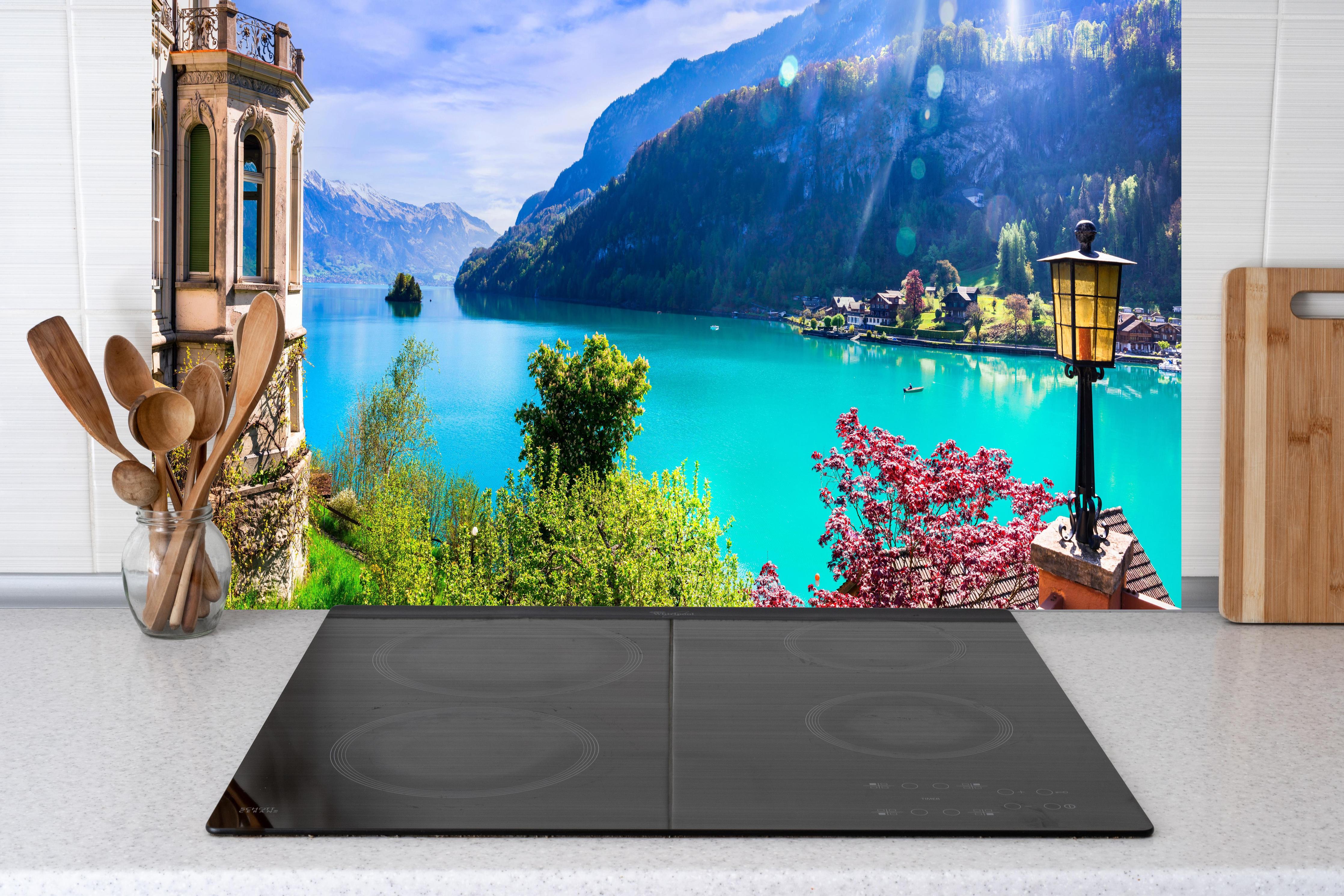 Küche - Naturkulisse des Brienzersees - Schweiz hinter weißen Hochglanz-Küchenregalen und schwarzem Wasserhahn