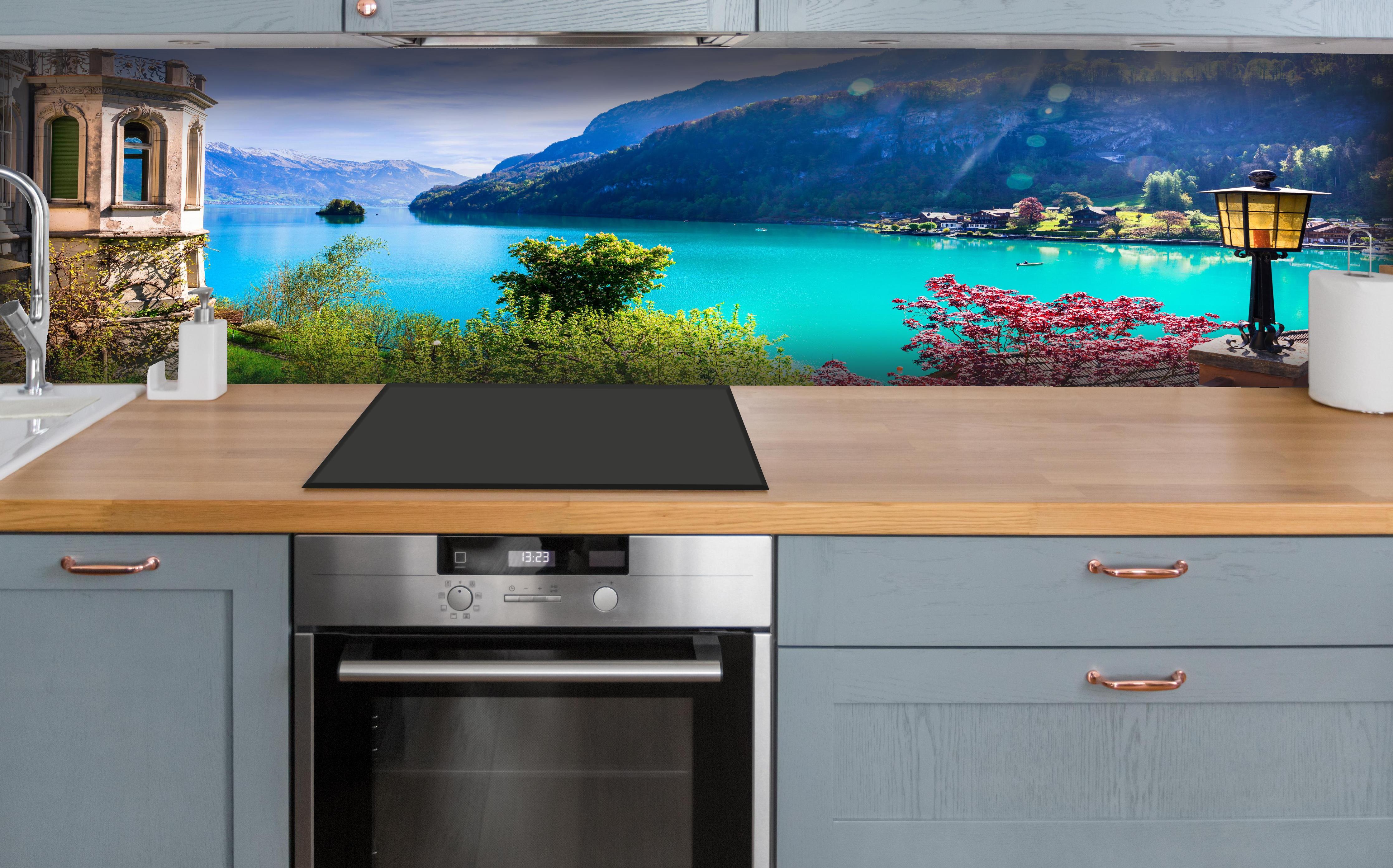 Küche - Naturkulisse des Brienzersees - Schweiz hinter weißen Hochglanz-Küchenregalen und schwarzem Wasserhahn