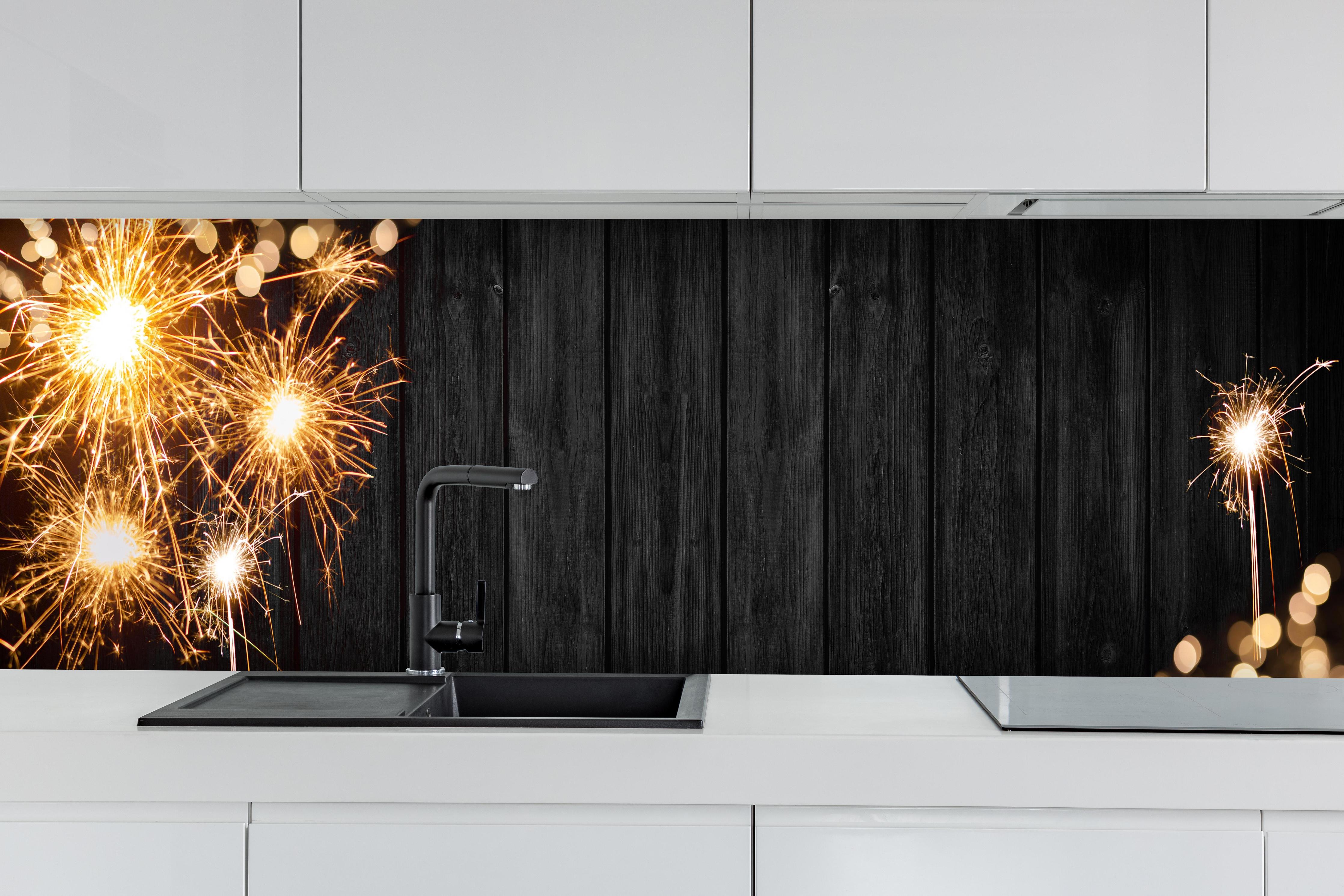 Küche - Neujahr Feuerwerk Funken auf Schwarz hinter weißen Hochglanz-Küchenregalen und schwarzem Wasserhahn