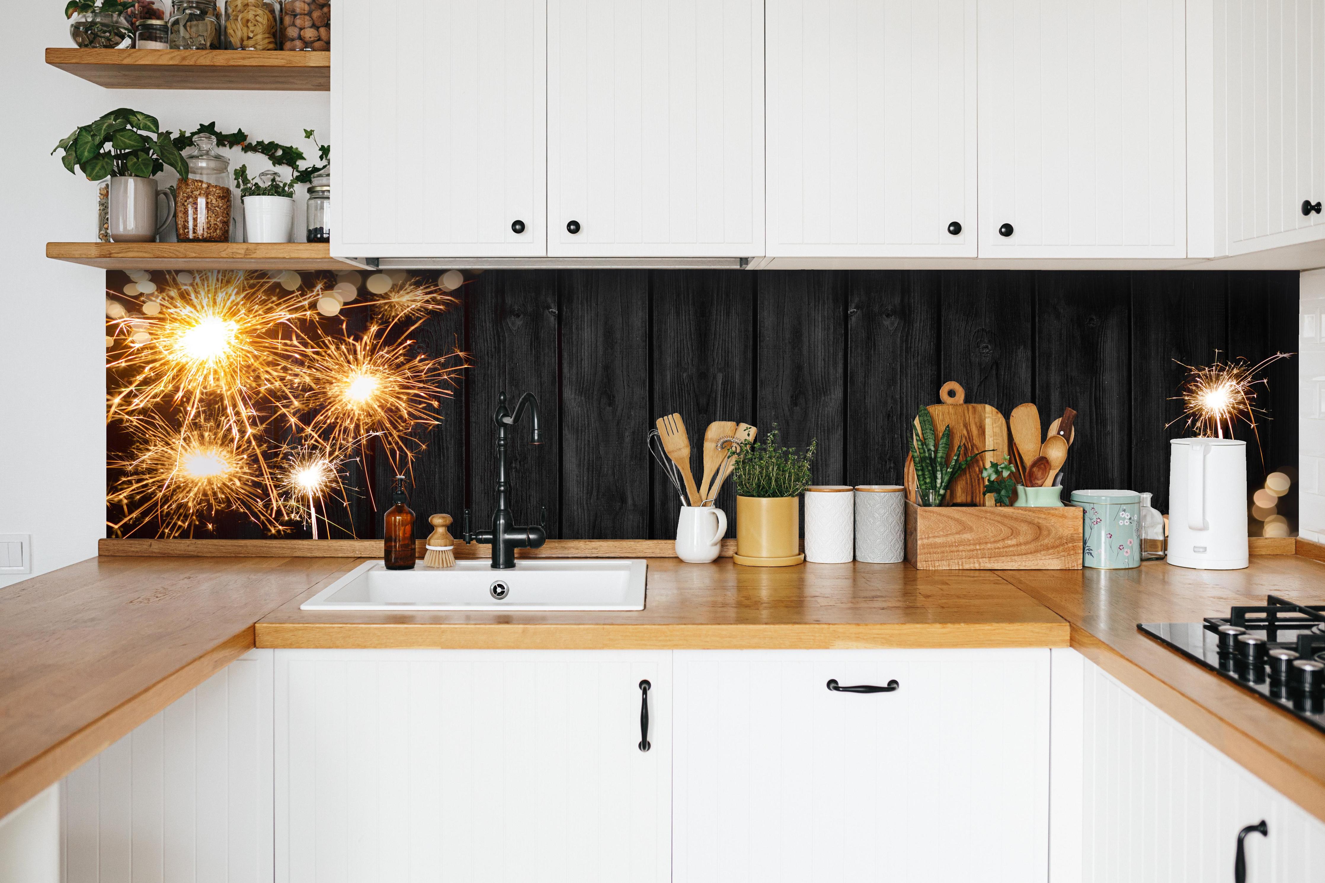 Küche - Neujahr Feuerwerk Funken auf Schwarz hinter weißen Hochglanz-Küchenregalen und schwarzem Wasserhahn