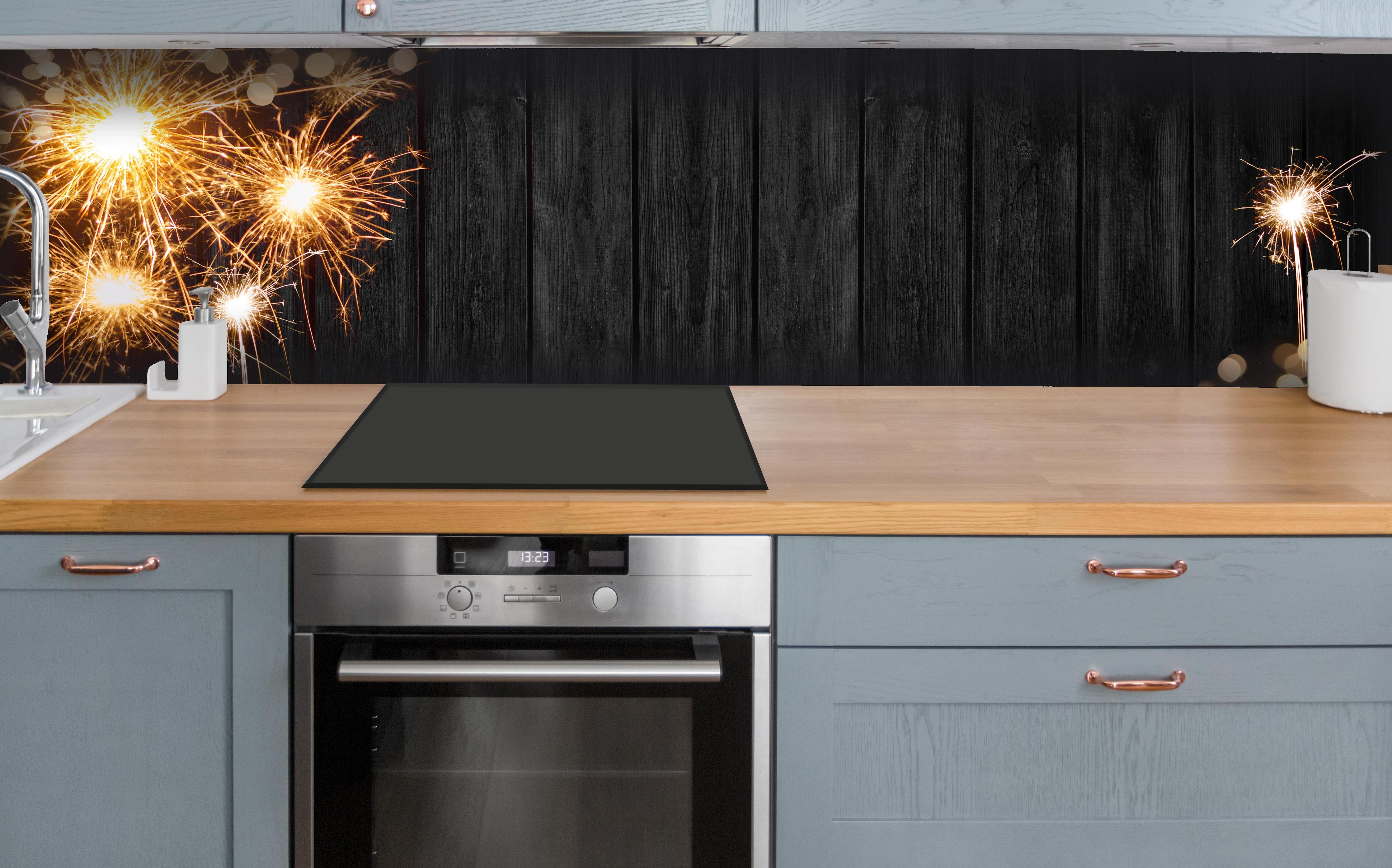 Küche - Neujahr Feuerwerk Funken auf Schwarz hinter weißen Hochglanz-Küchenregalen und schwarzem Wasserhahn