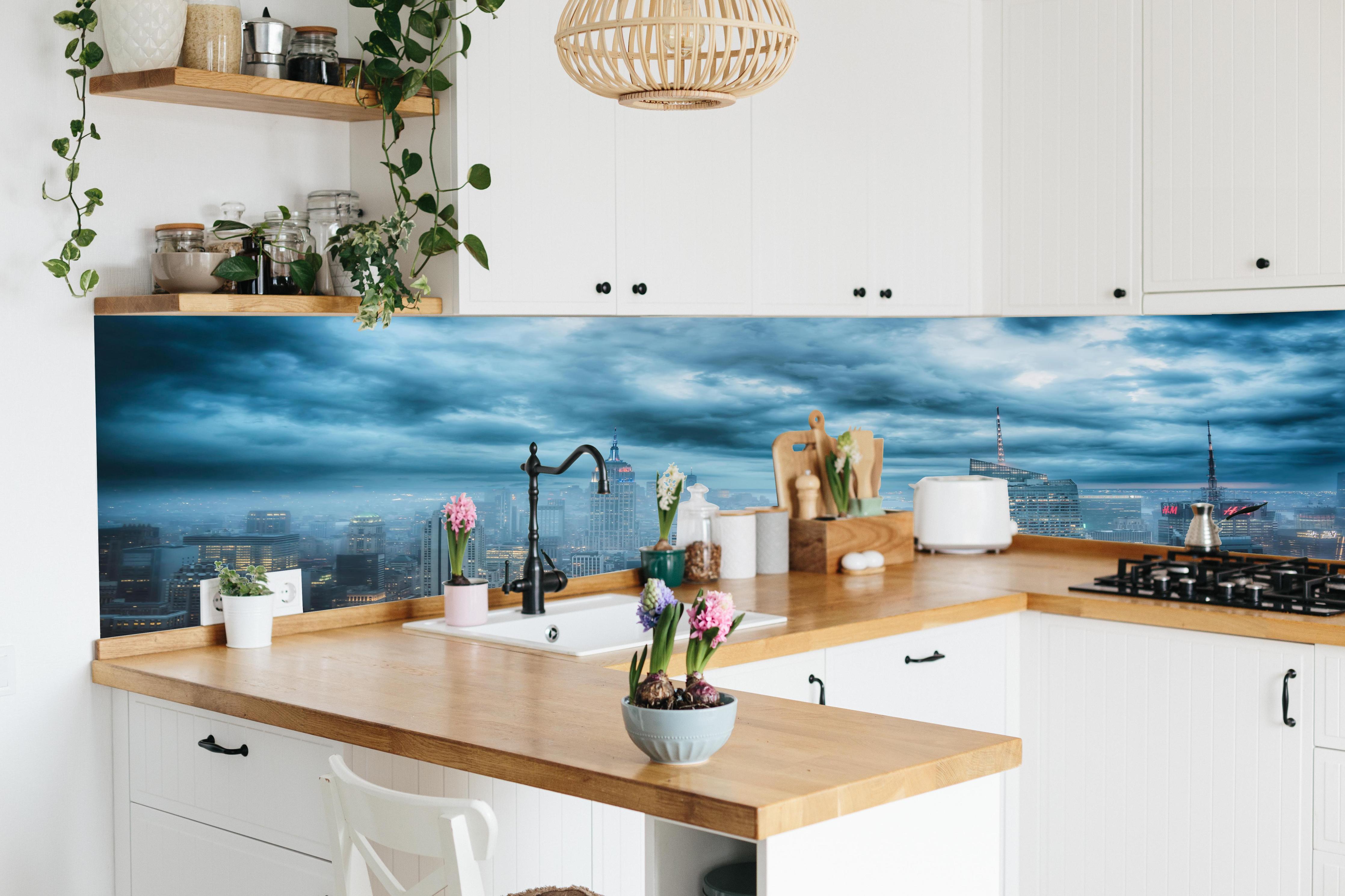 Küche - New York Skyline hinter weißen Hochglanz-Küchenregalen und schwarzem Wasserhahn