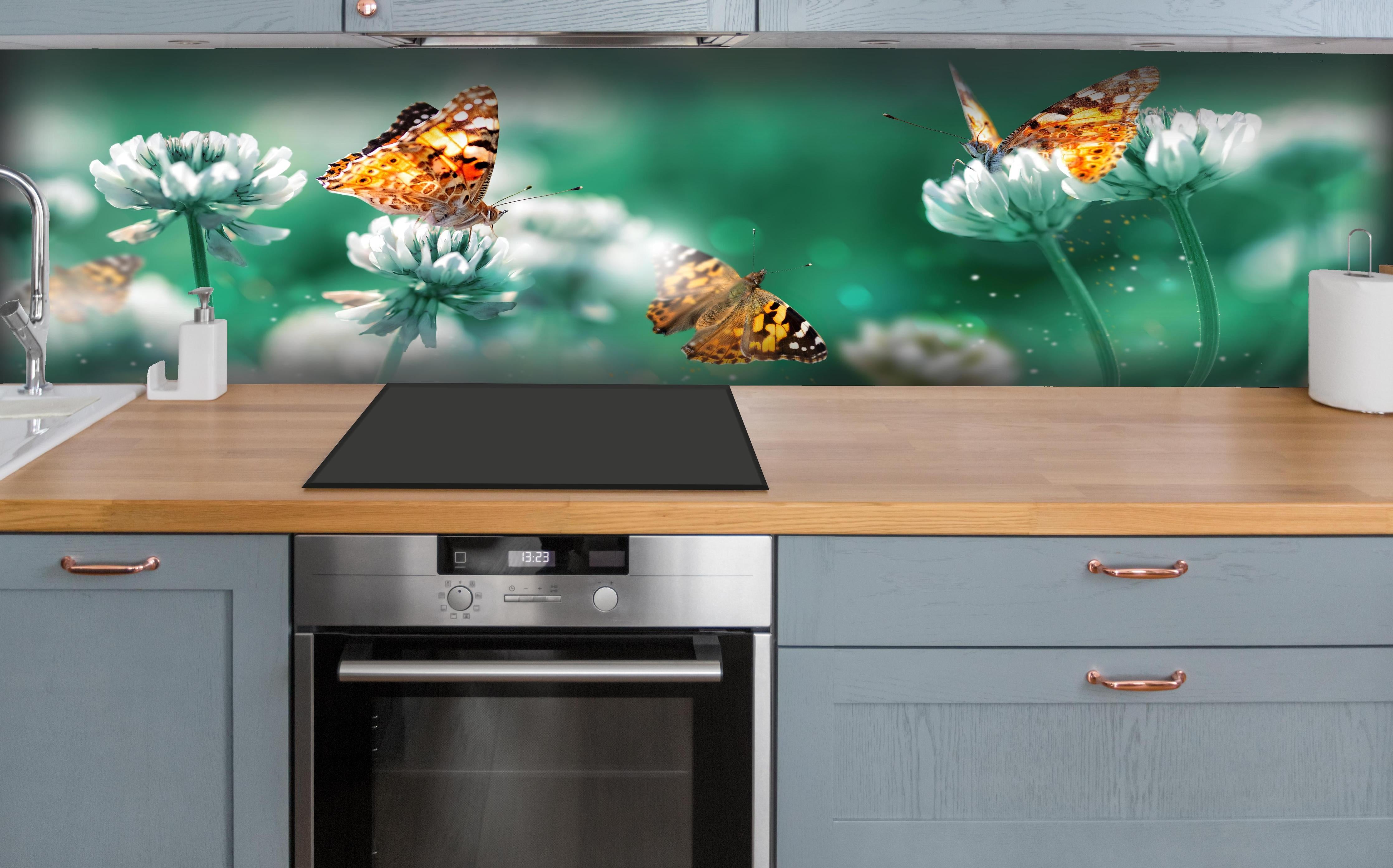 Küche - Orange Schmetterlinge Sommergarten hinter weißen Hochglanz-Küchenregalen und schwarzem Wasserhahn