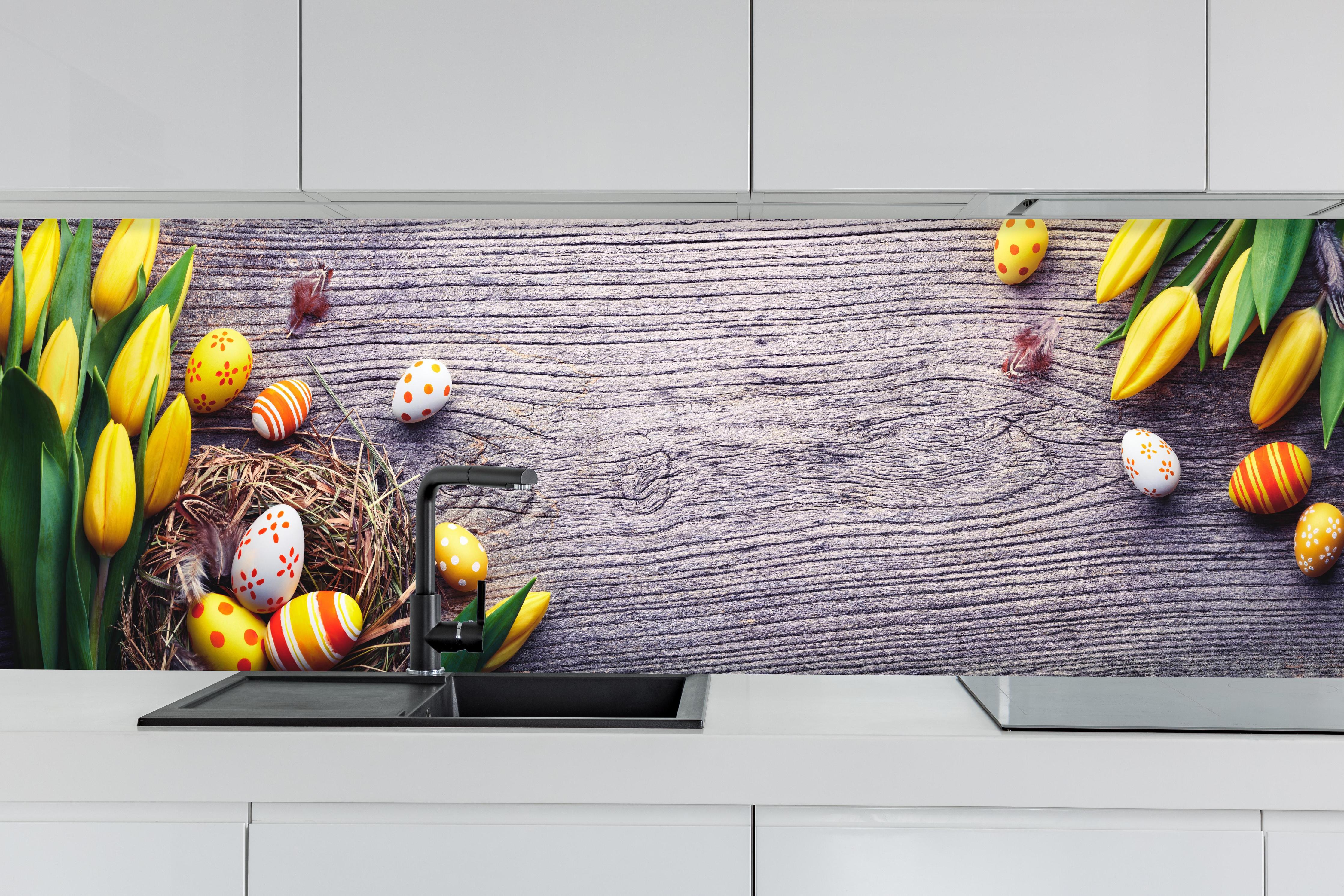 Küche - Ostereier auf Holztisch hinter weißen Hochglanz-Küchenregalen und schwarzem Wasserhahn