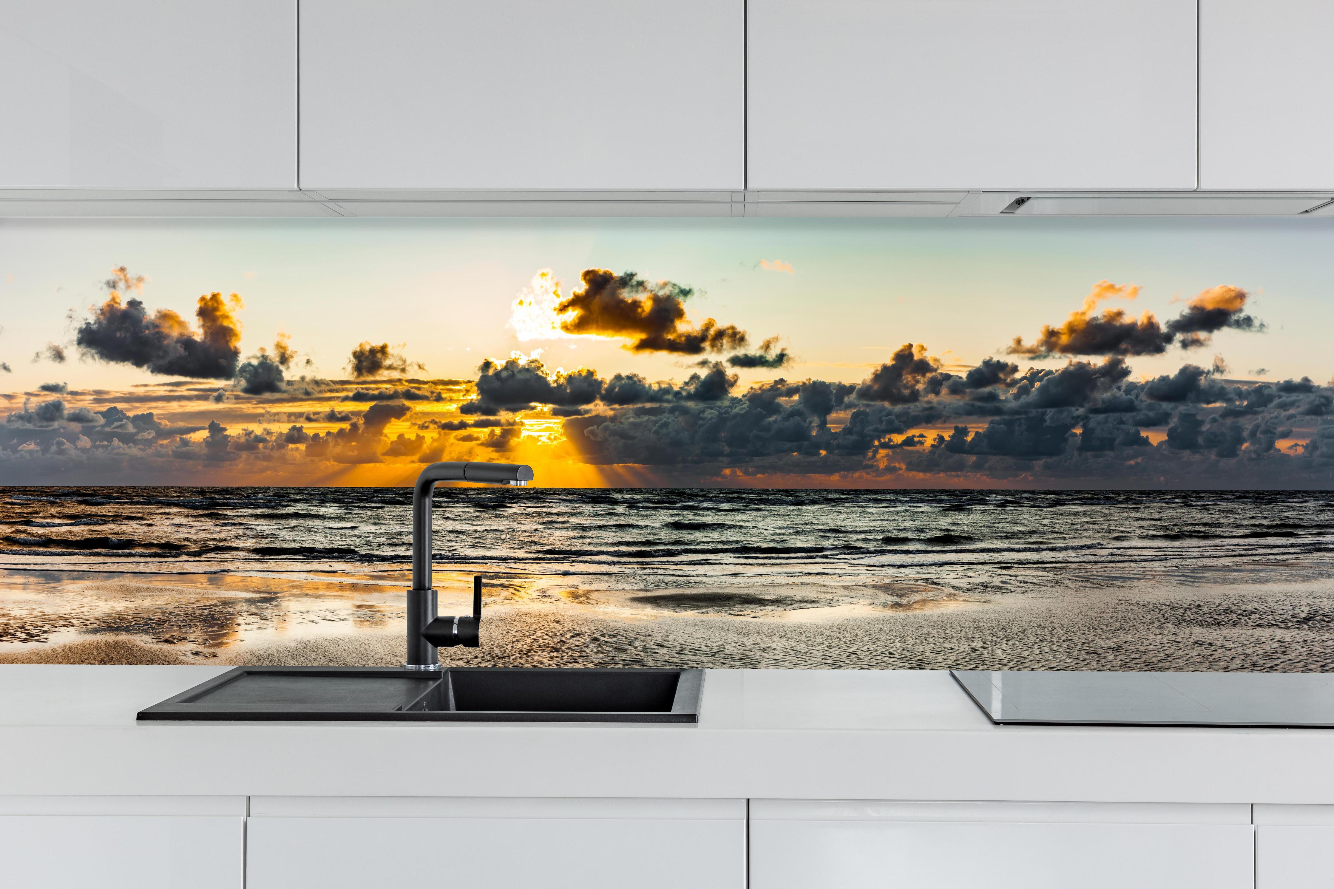 Küche - Panoramablick auf Sonnenuntergang über dem ruhigen Ozean hinter weißen Hochglanz-Küchenregalen und schwarzem Wasserhahn