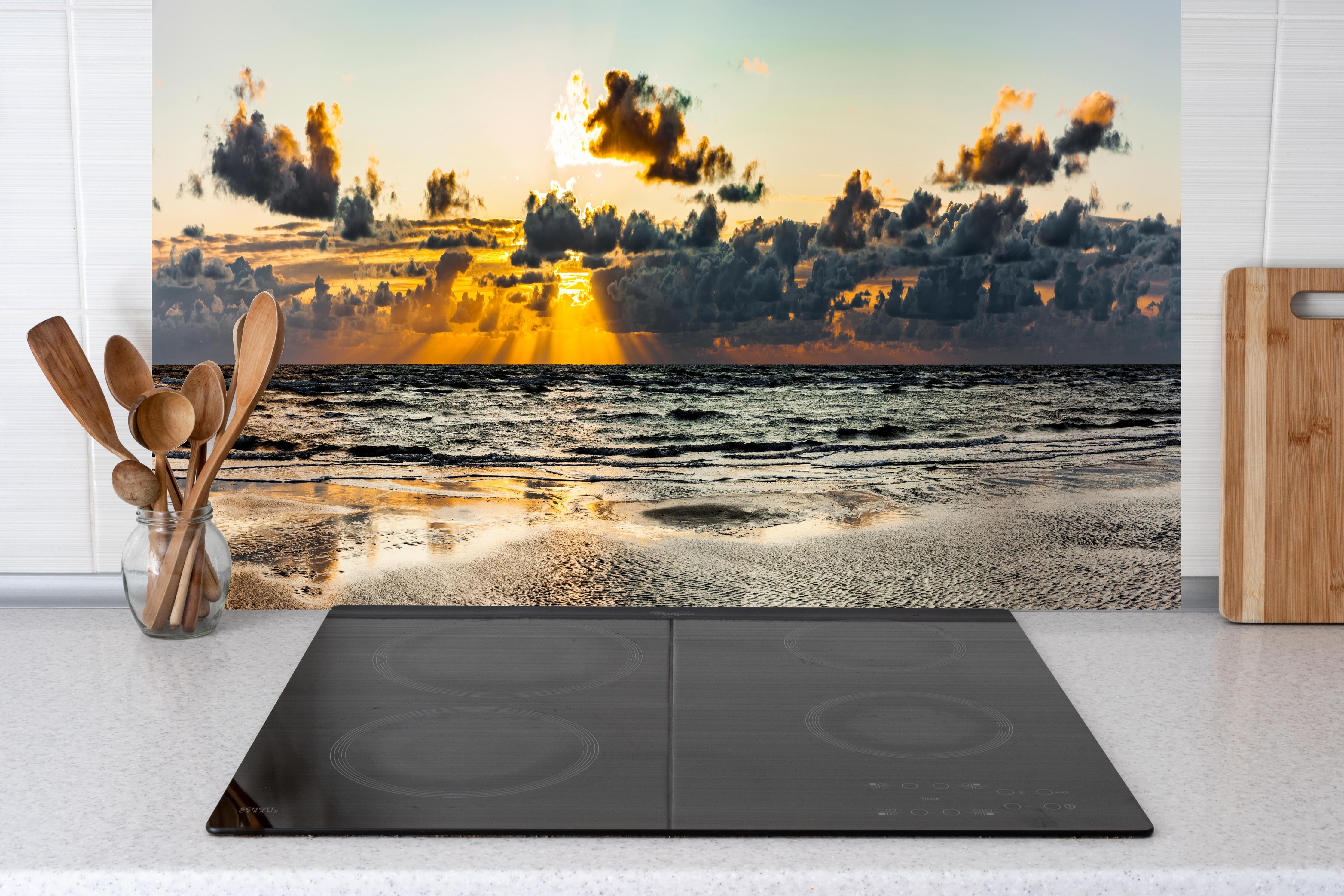 Küche - Panoramablick auf Sonnenuntergang über dem ruhigen Ozean hinter weißen Hochglanz-Küchenregalen und schwarzem Wasserhahn