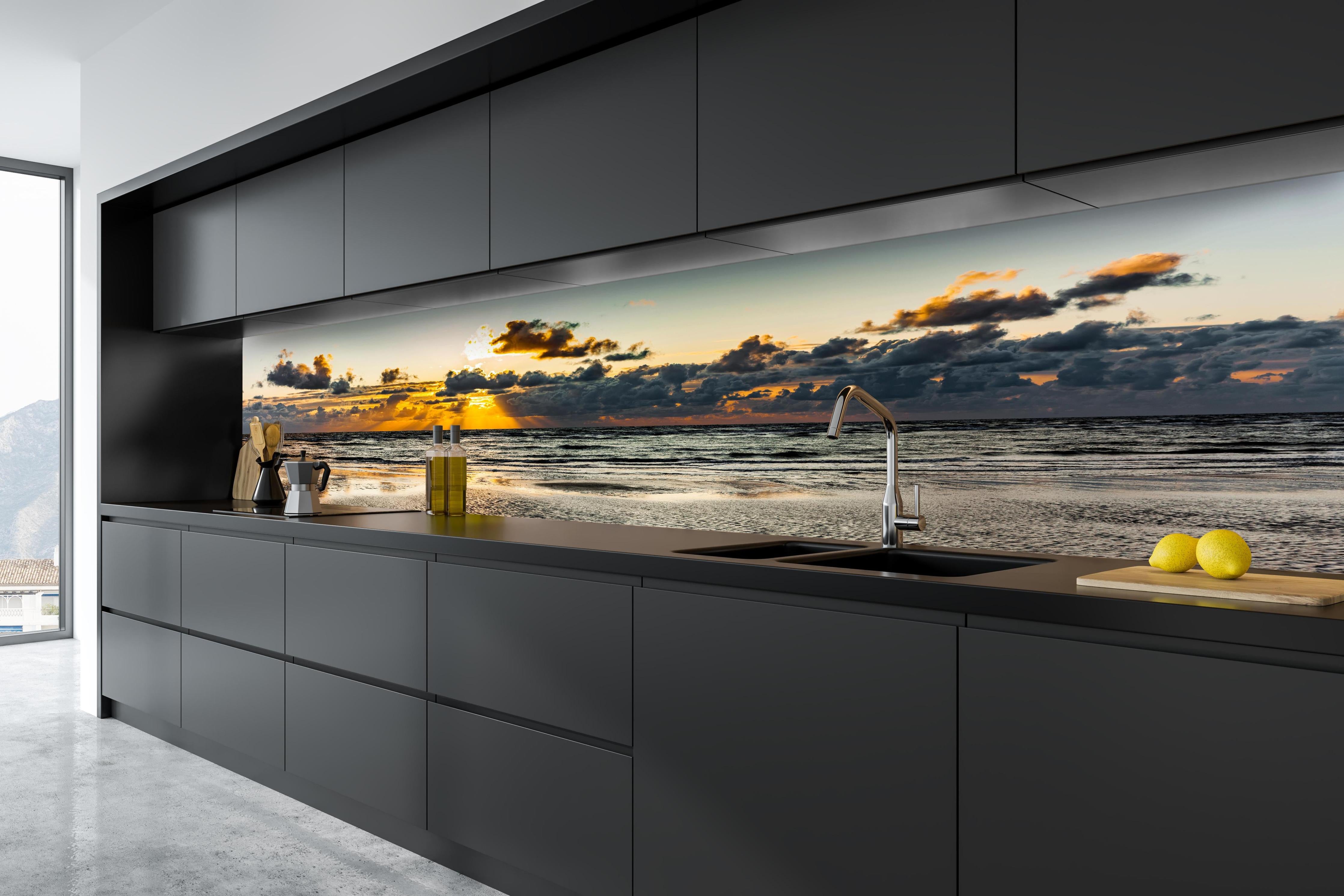 Küche - Panoramablick auf Sonnenuntergang über dem ruhigen Ozean hinter weißen Hochglanz-Küchenregalen und schwarzem Wasserhahn