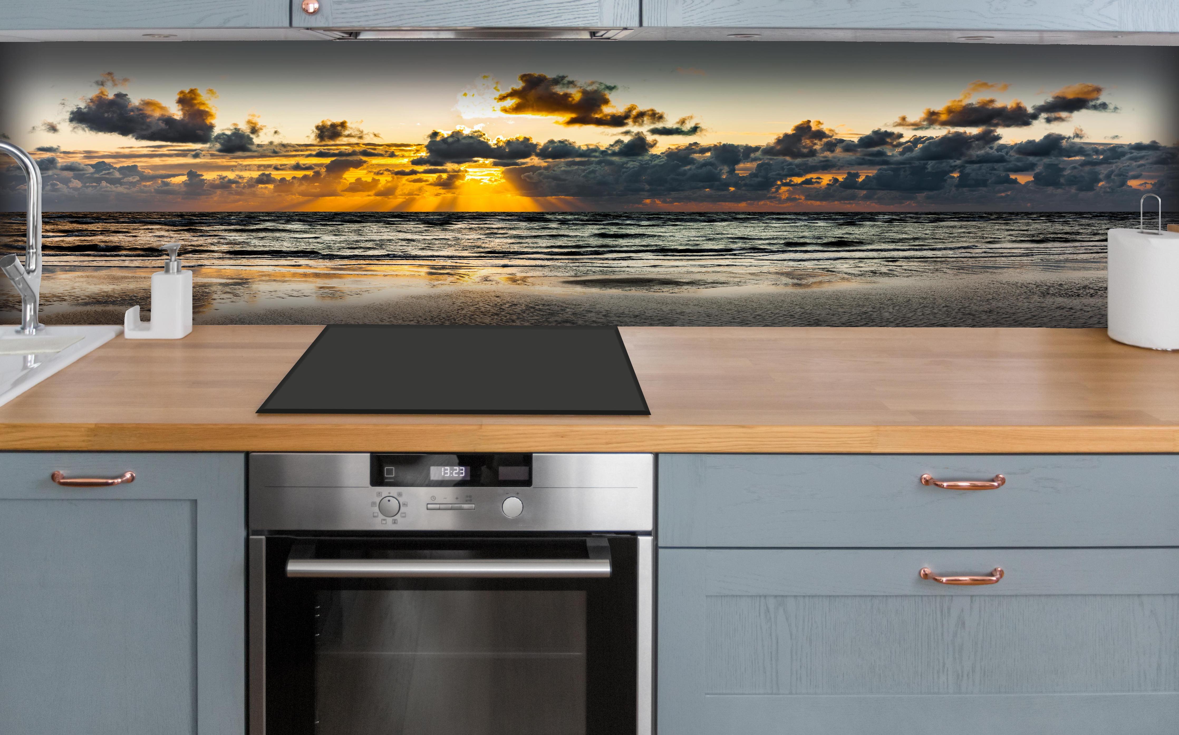 Küche - Panoramablick auf Sonnenuntergang über dem ruhigen Ozean hinter weißen Hochglanz-Küchenregalen und schwarzem Wasserhahn