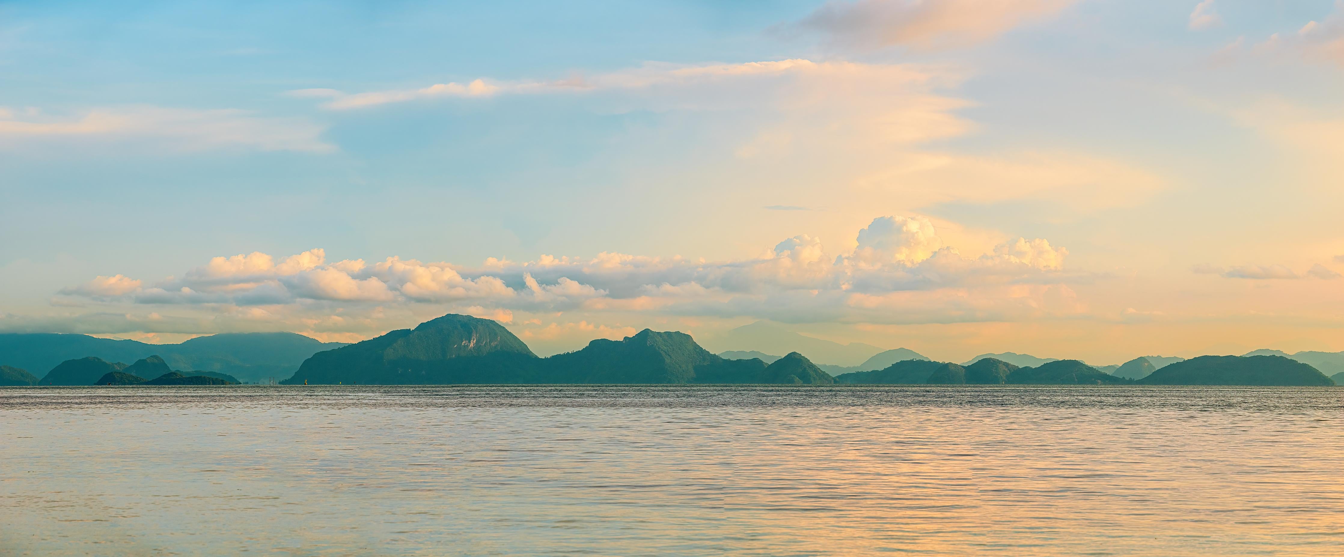 Küchenrückwand-Panoramablick auf idyllische Küstenlandschaft mit Berge im Hintergrund