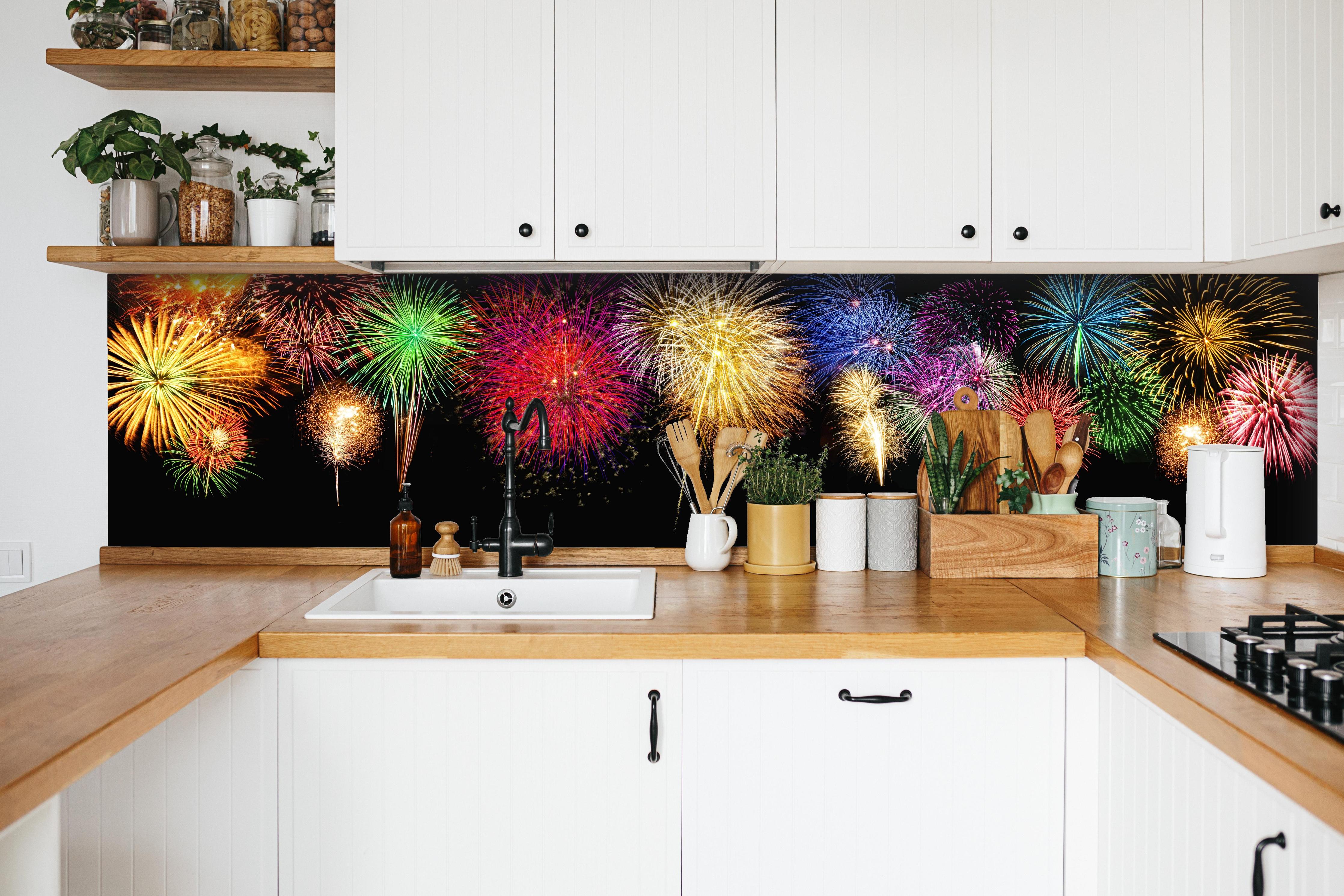 Küche - Panoramisches Silvesterfeuerwerk in leuchtenden Farben hinter weißen Hochglanz-Küchenregalen und schwarzem Wasserhahn