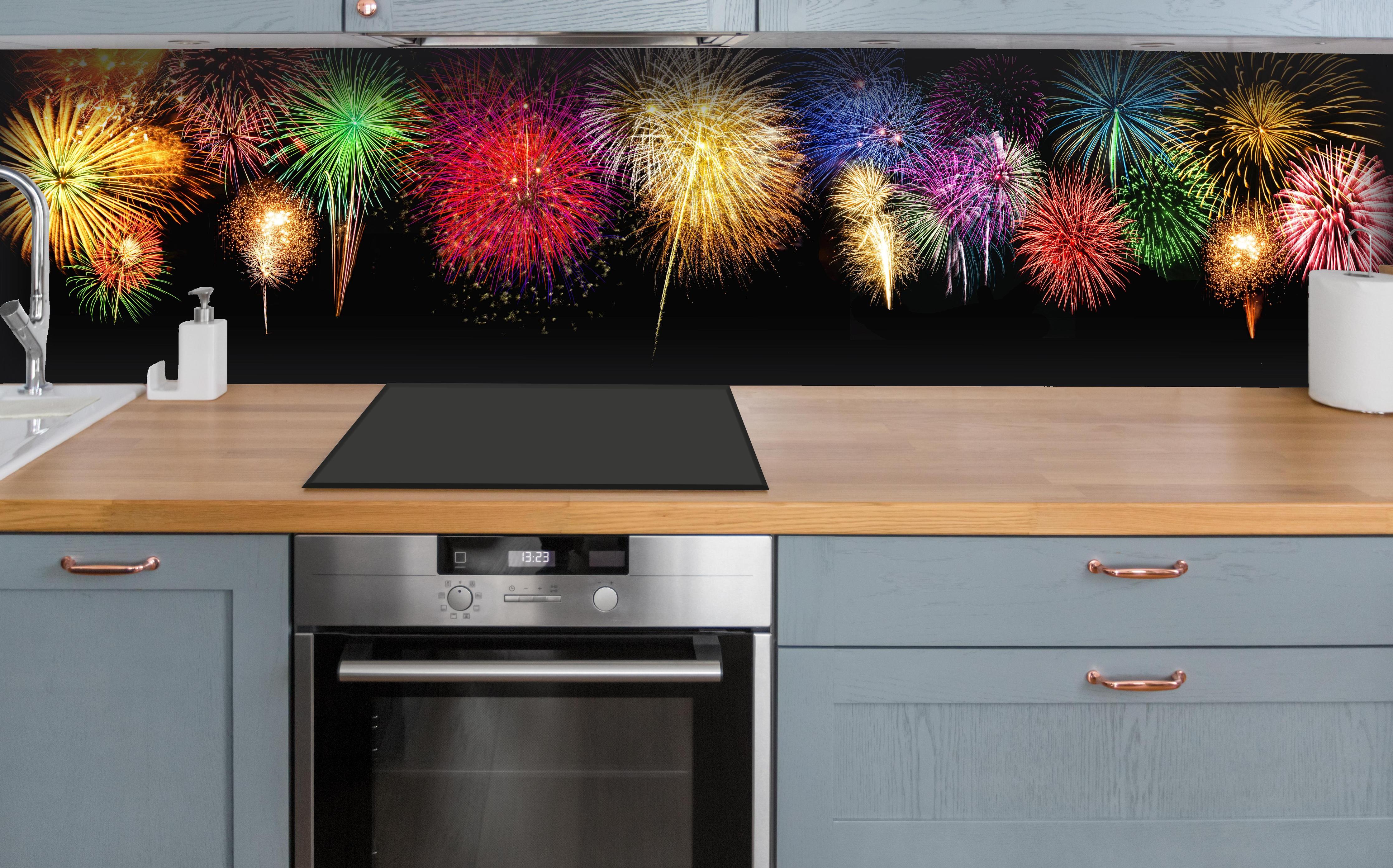 Küche - Panoramisches Silvesterfeuerwerk in leuchtenden Farben hinter weißen Hochglanz-Küchenregalen und schwarzem Wasserhahn