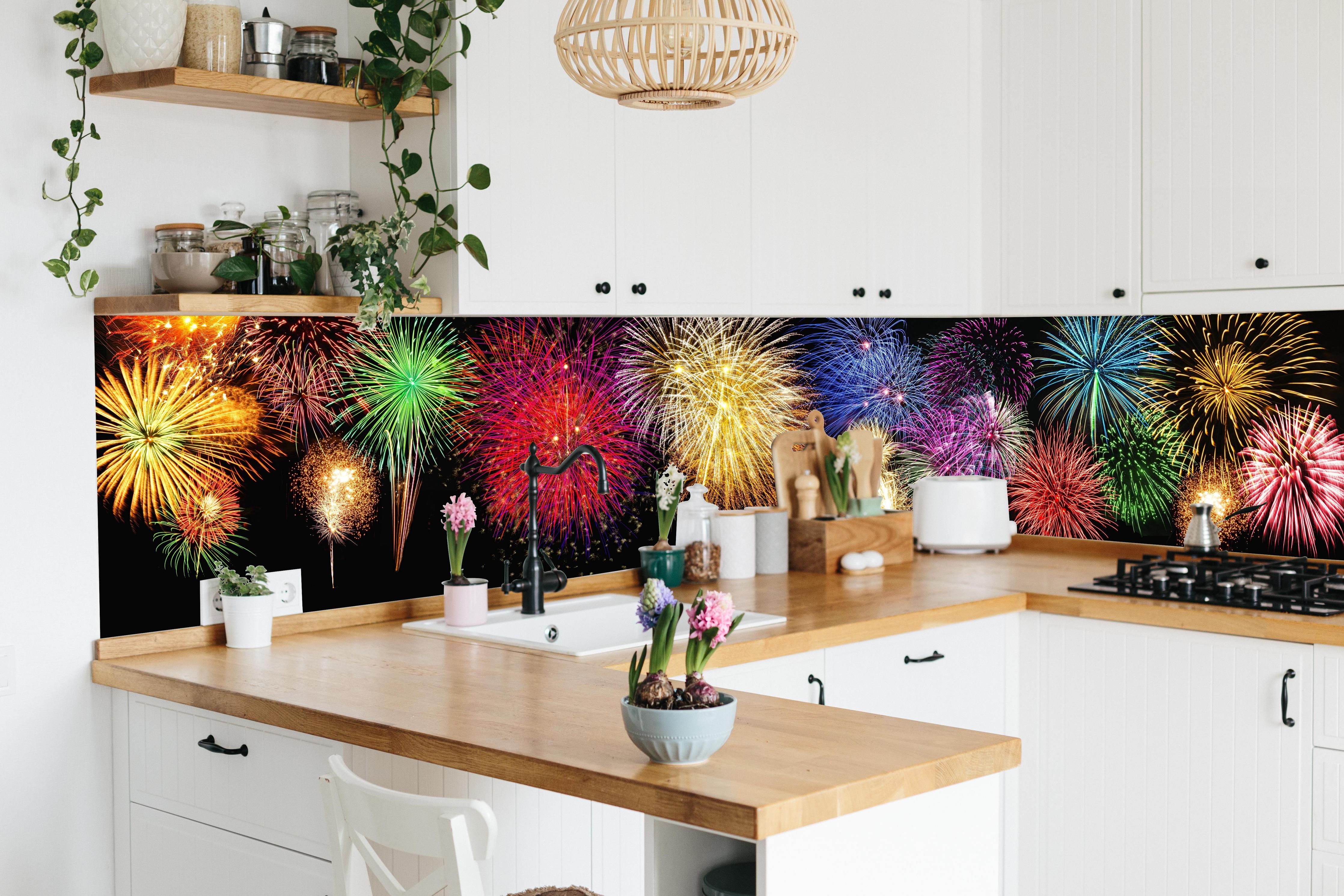 Küche - Panoramisches Silvesterfeuerwerk in leuchtenden Farben hinter weißen Hochglanz-Küchenregalen und schwarzem Wasserhahn