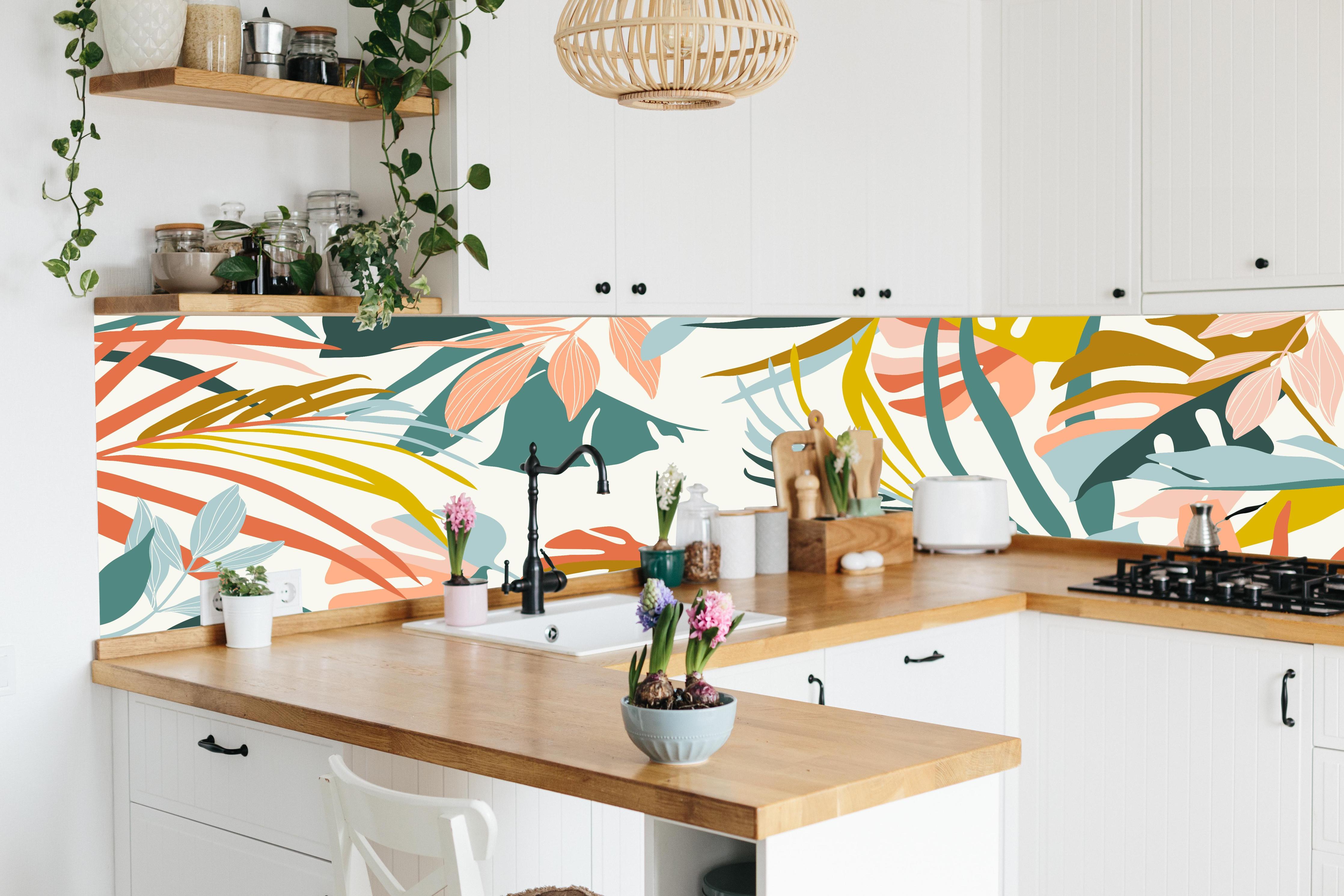 Küche - Pastell Tropenblätter stilvolle Wanddekoration hinter weißen Hochglanz-Küchenregalen und schwarzem Wasserhahn