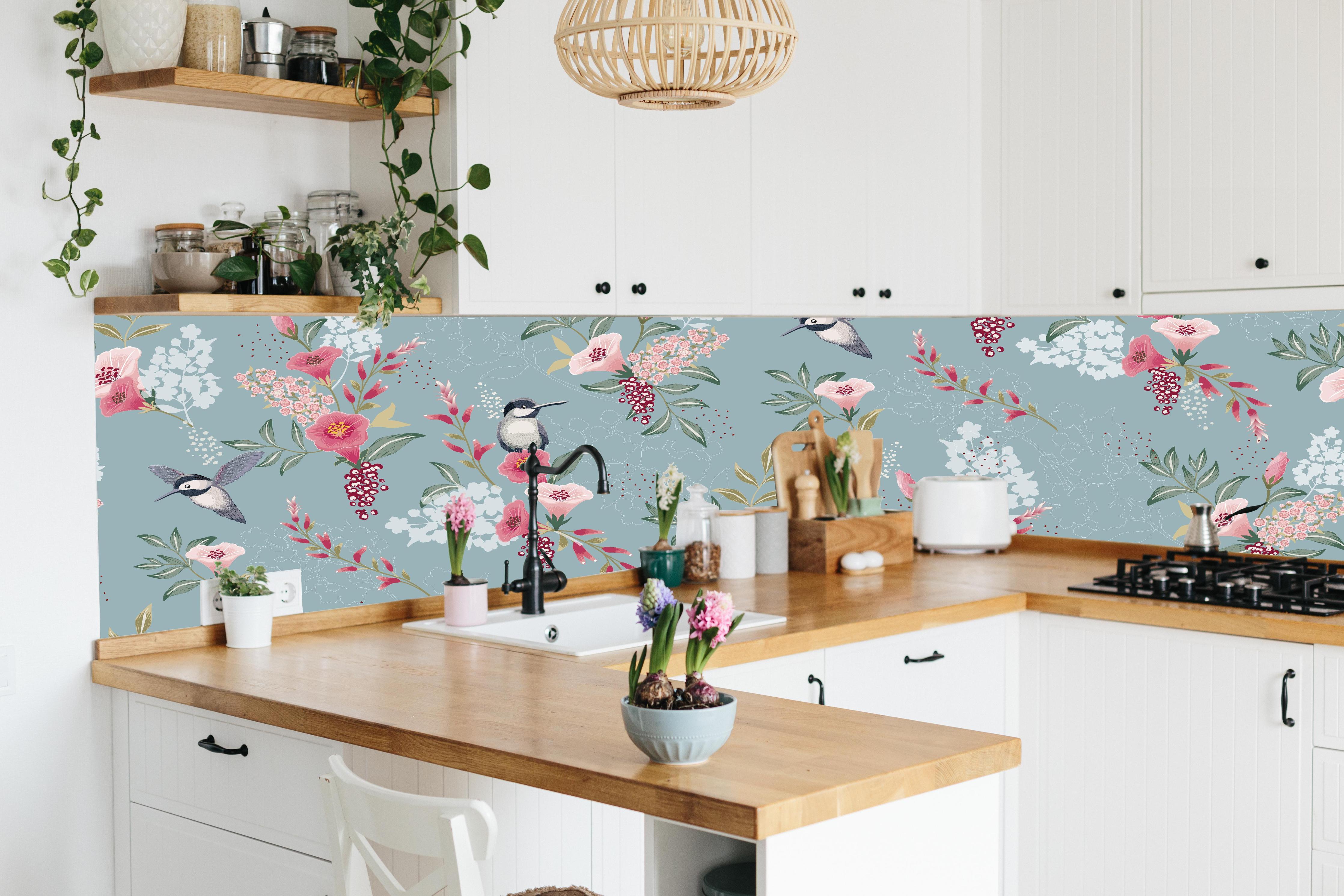 Küche - Pastellfarbenes Blumenmuster mit Kohlmeisen hinter weißen Hochglanz-Küchenregalen und schwarzem Wasserhahn
