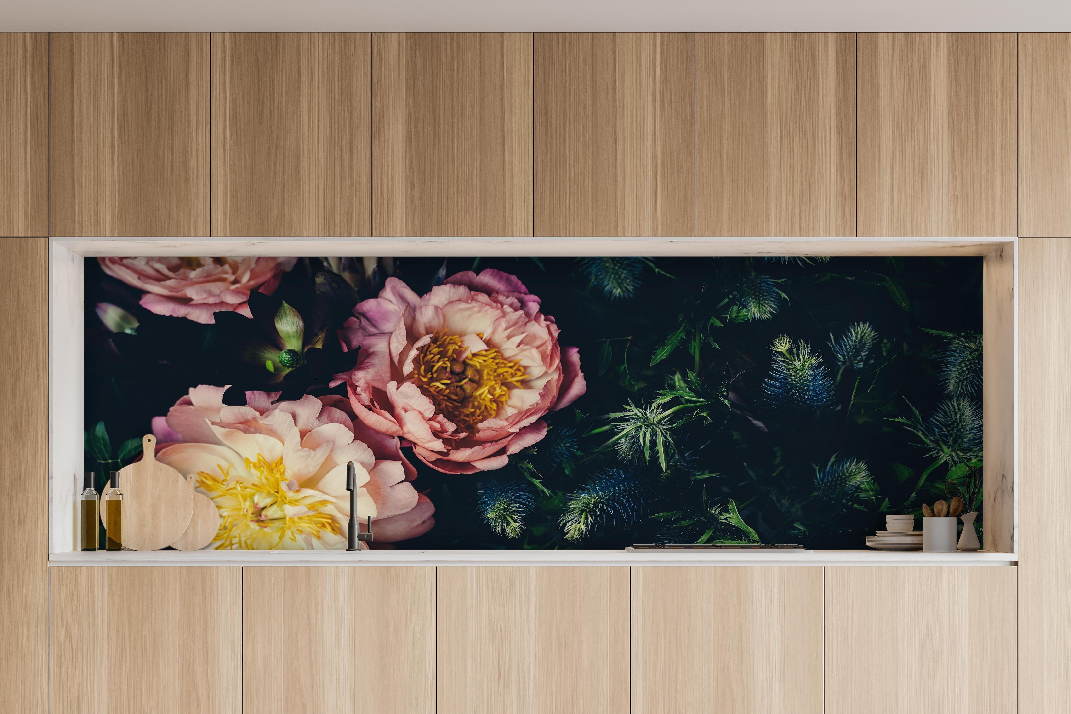 Küche - Rosa Blüten auf einer Wiese hinter weißen Hochglanz-Küchenregalen und schwarzem Wasserhahn