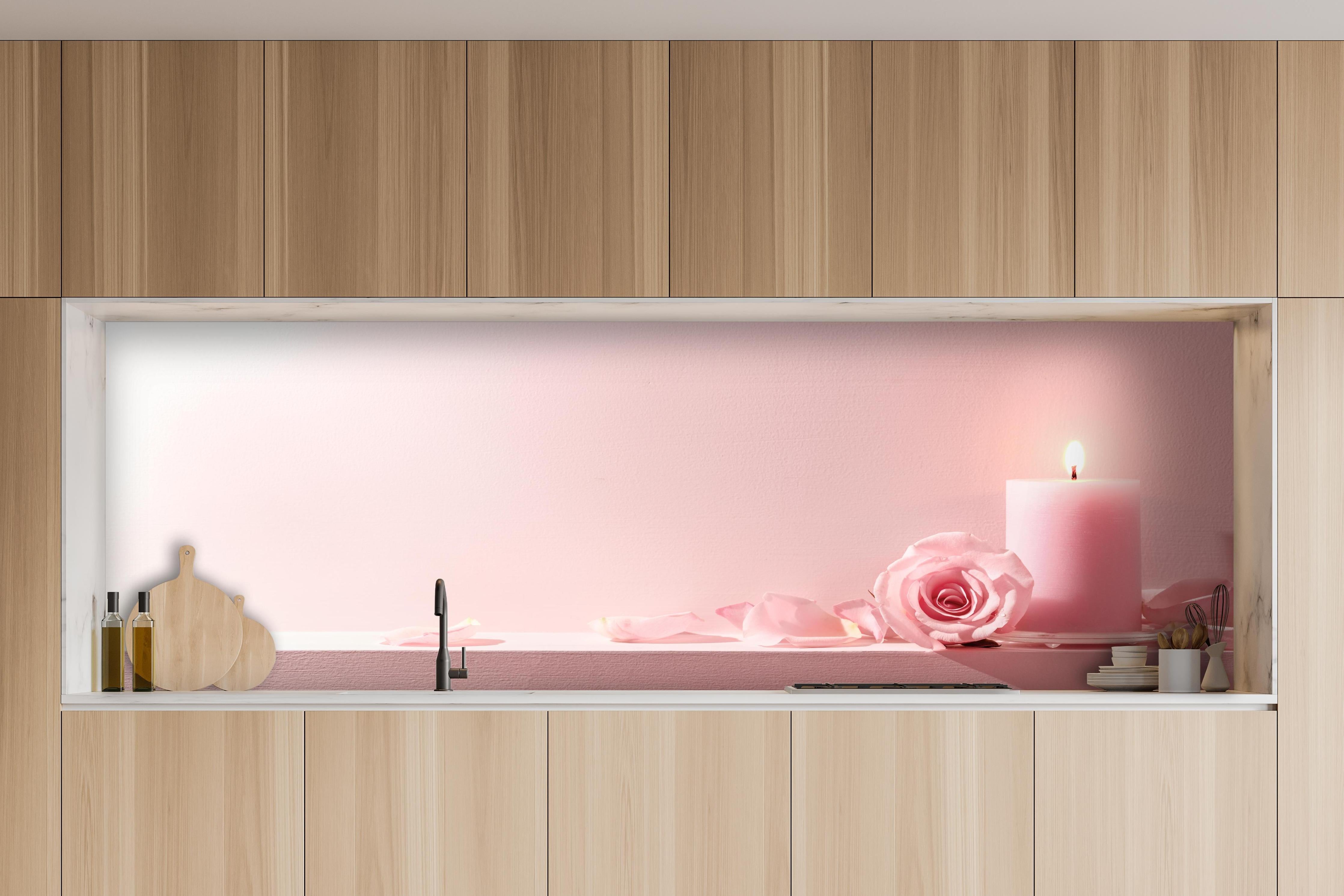 Küche - Rosa Rosen und Kerze auf einem rosa Hintergrund hinter weißen Hochglanz-Küchenregalen und schwarzem Wasserhahn