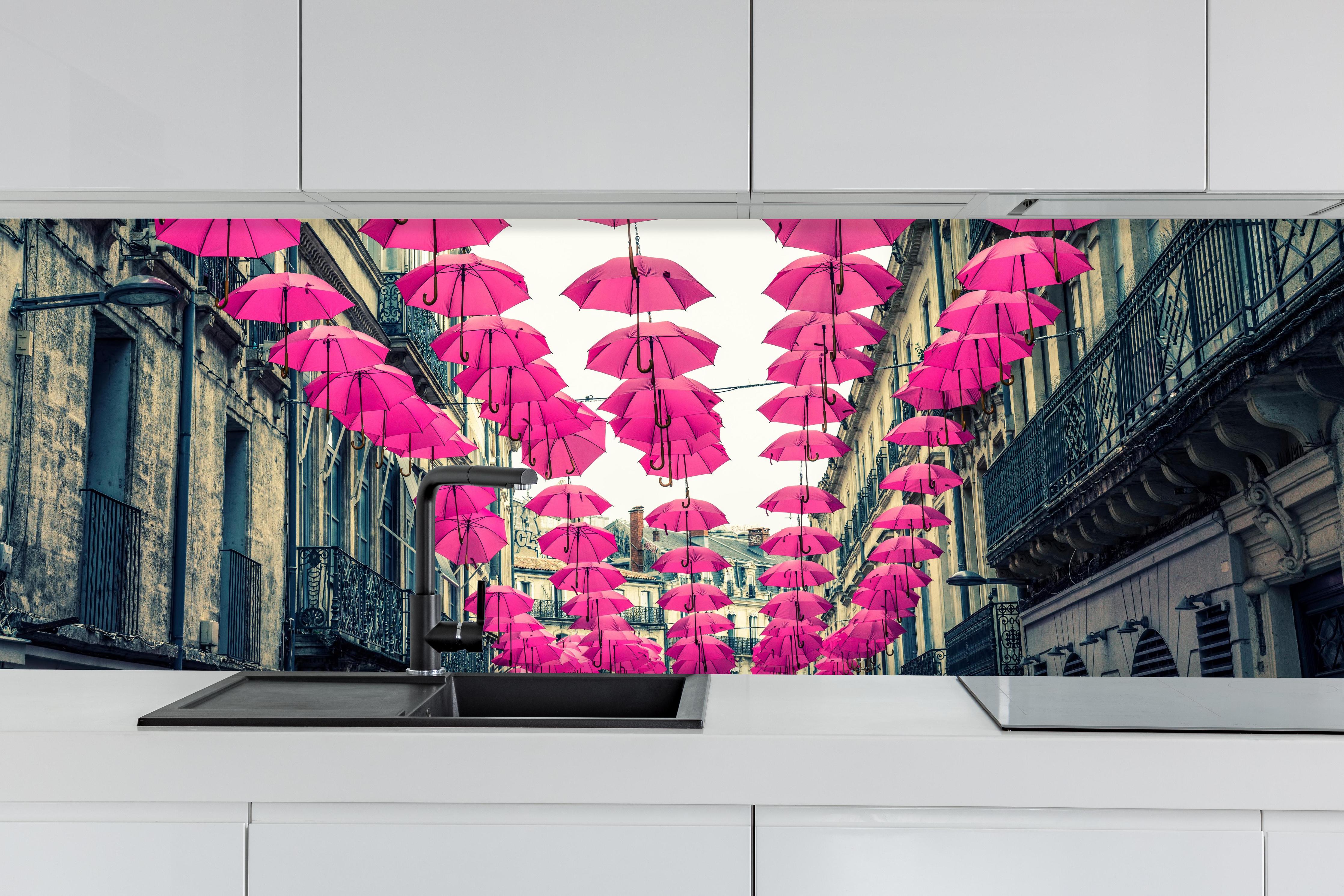 Küche - Rosafarbene Regenschirme als Straßenkunst hinter weißen Hochglanz-Küchenregalen und schwarzem Wasserhahn