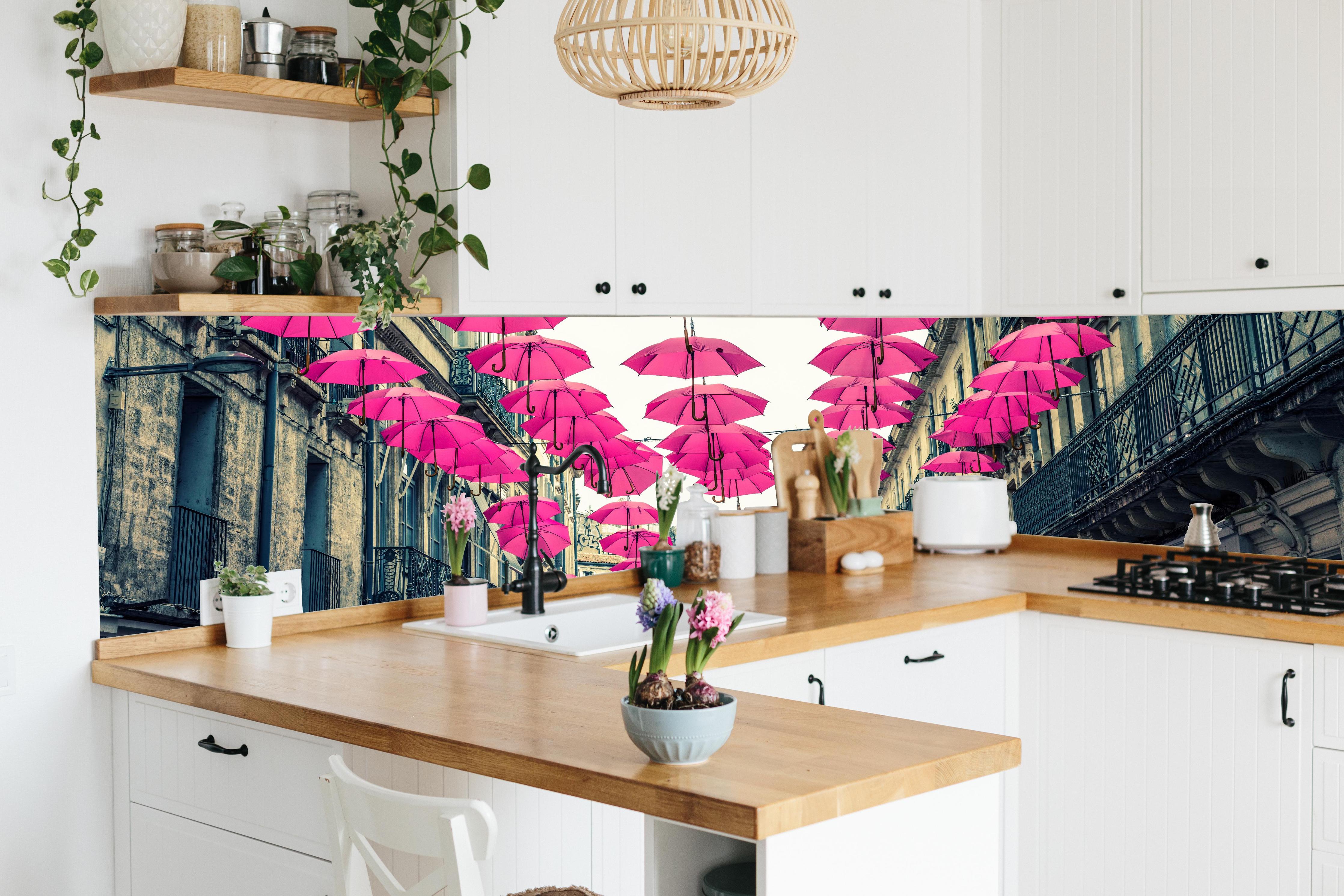 Küche - Rosafarbene Regenschirme als Straßenkunst hinter weißen Hochglanz-Küchenregalen und schwarzem Wasserhahn