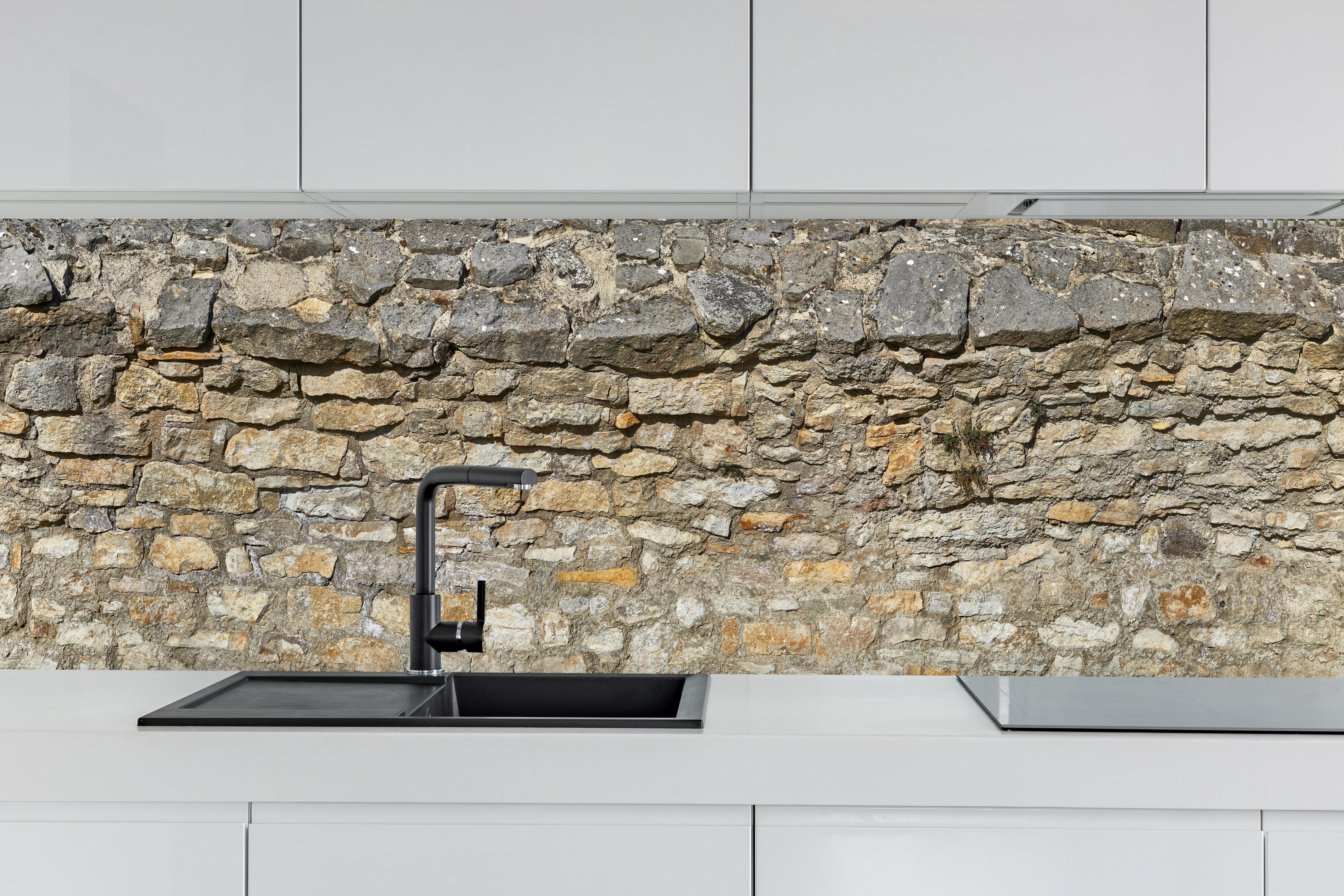 Küche - Rustikale Burgmauer hinter weißen Hochglanz-Küchenregalen und schwarzem Wasserhahn