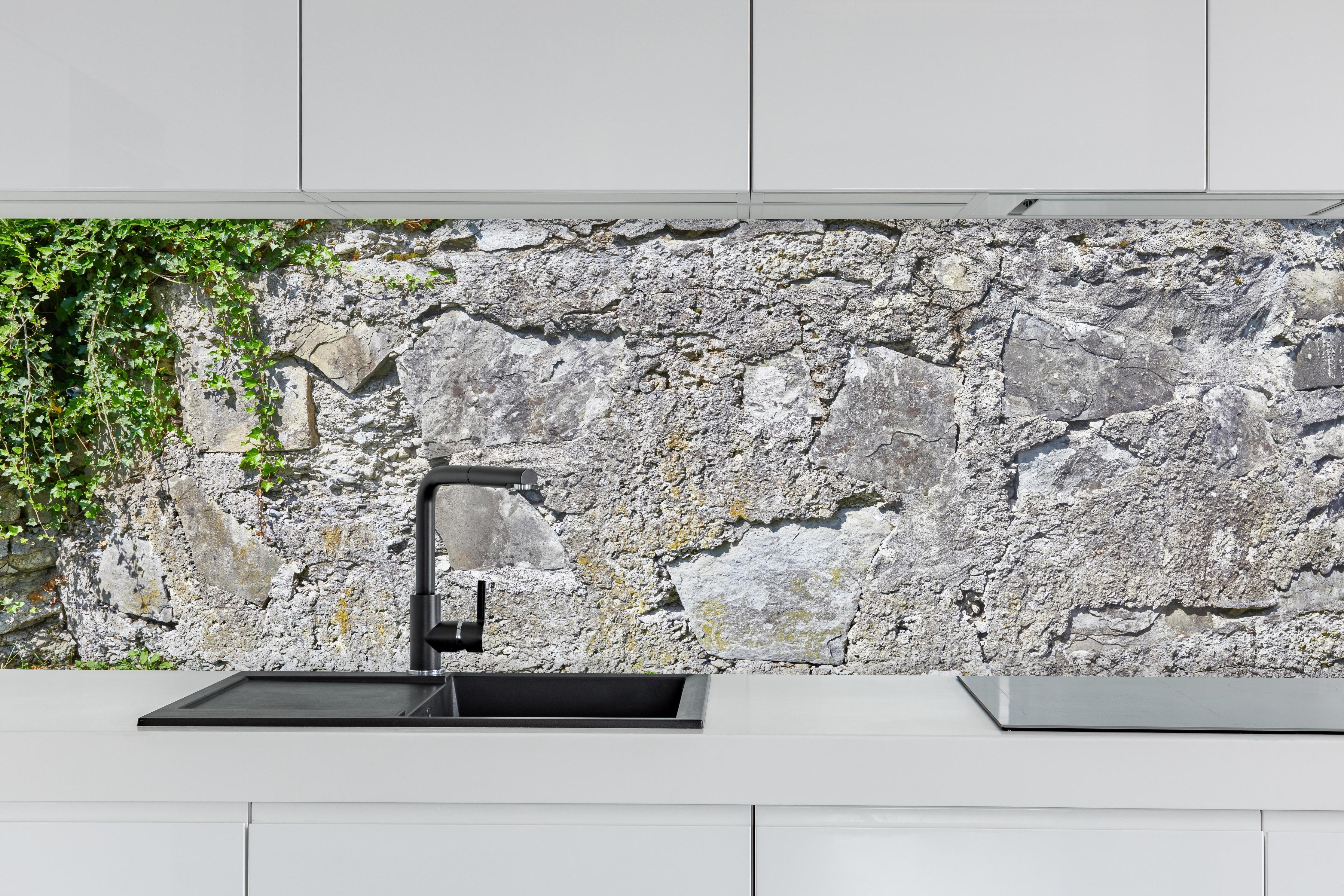 Küche - Rustikale Schiefermauer hinter weißen Hochglanz-Küchenregalen und schwarzem Wasserhahn