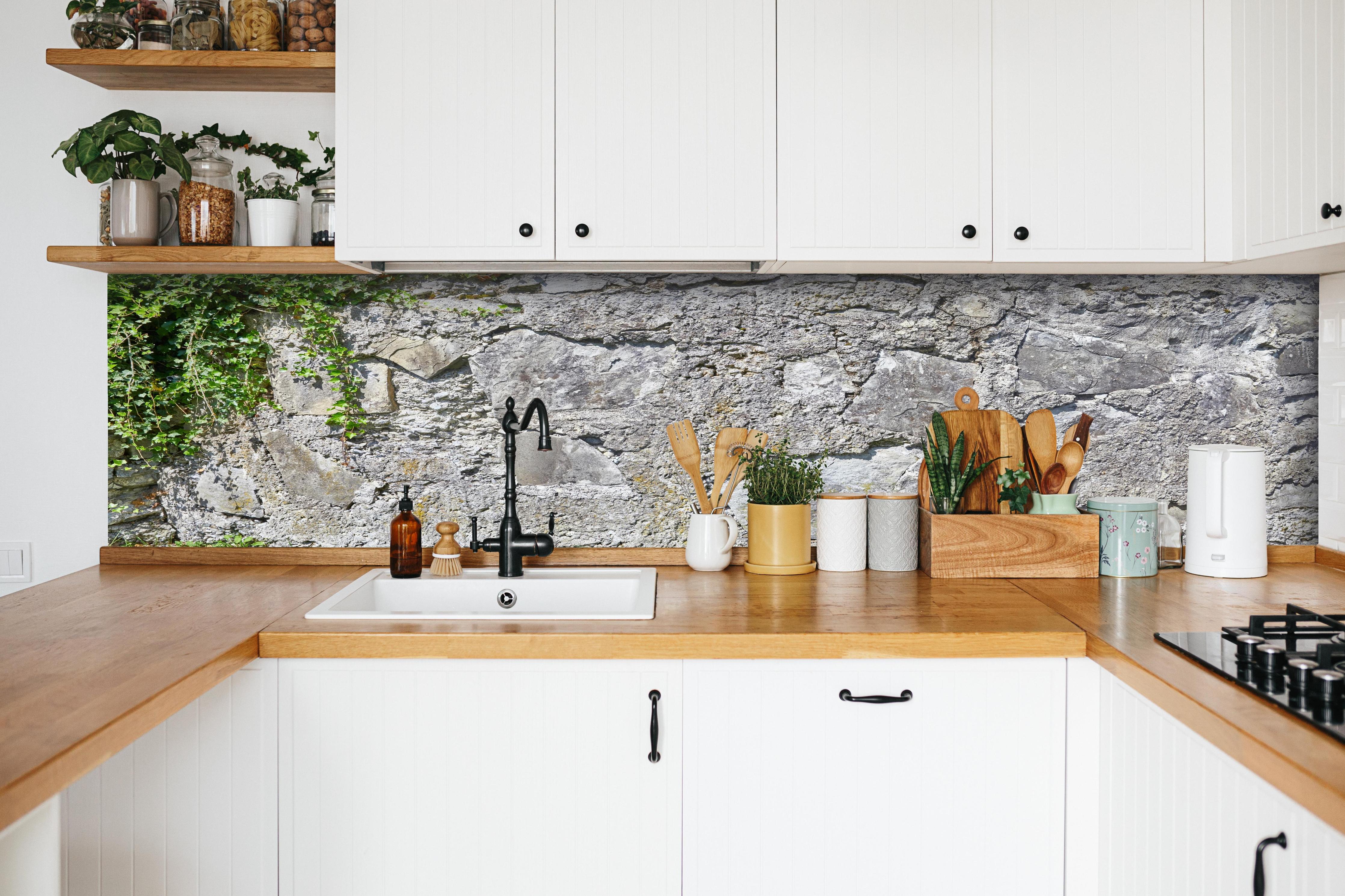 Küche - Rustikale Schiefermauer hinter weißen Hochglanz-Küchenregalen und schwarzem Wasserhahn