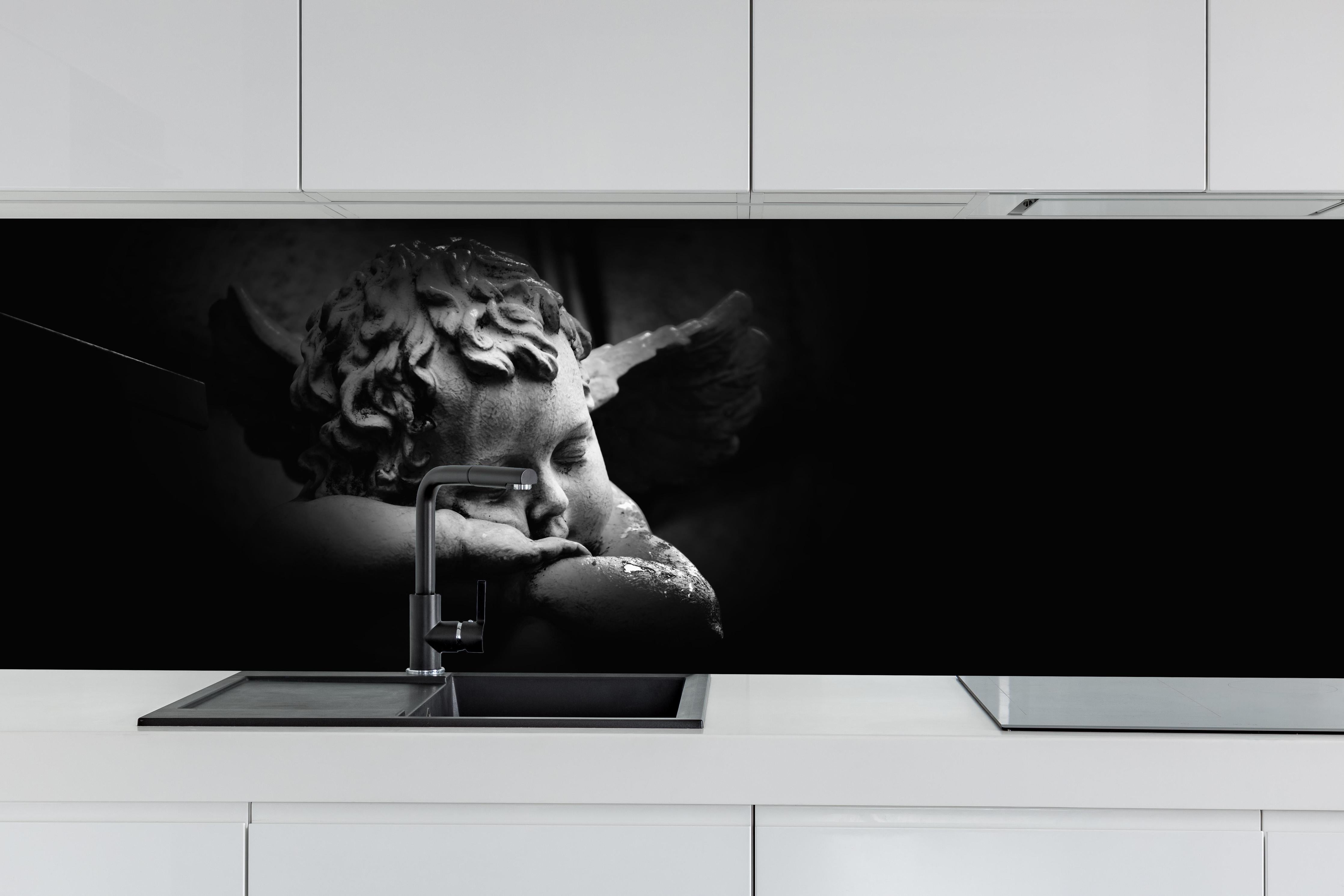 Küche - Schlafender Engel Statue in Schwarz-Weiß hinter weißen Hochglanz-Küchenregalen und schwarzem Wasserhahn