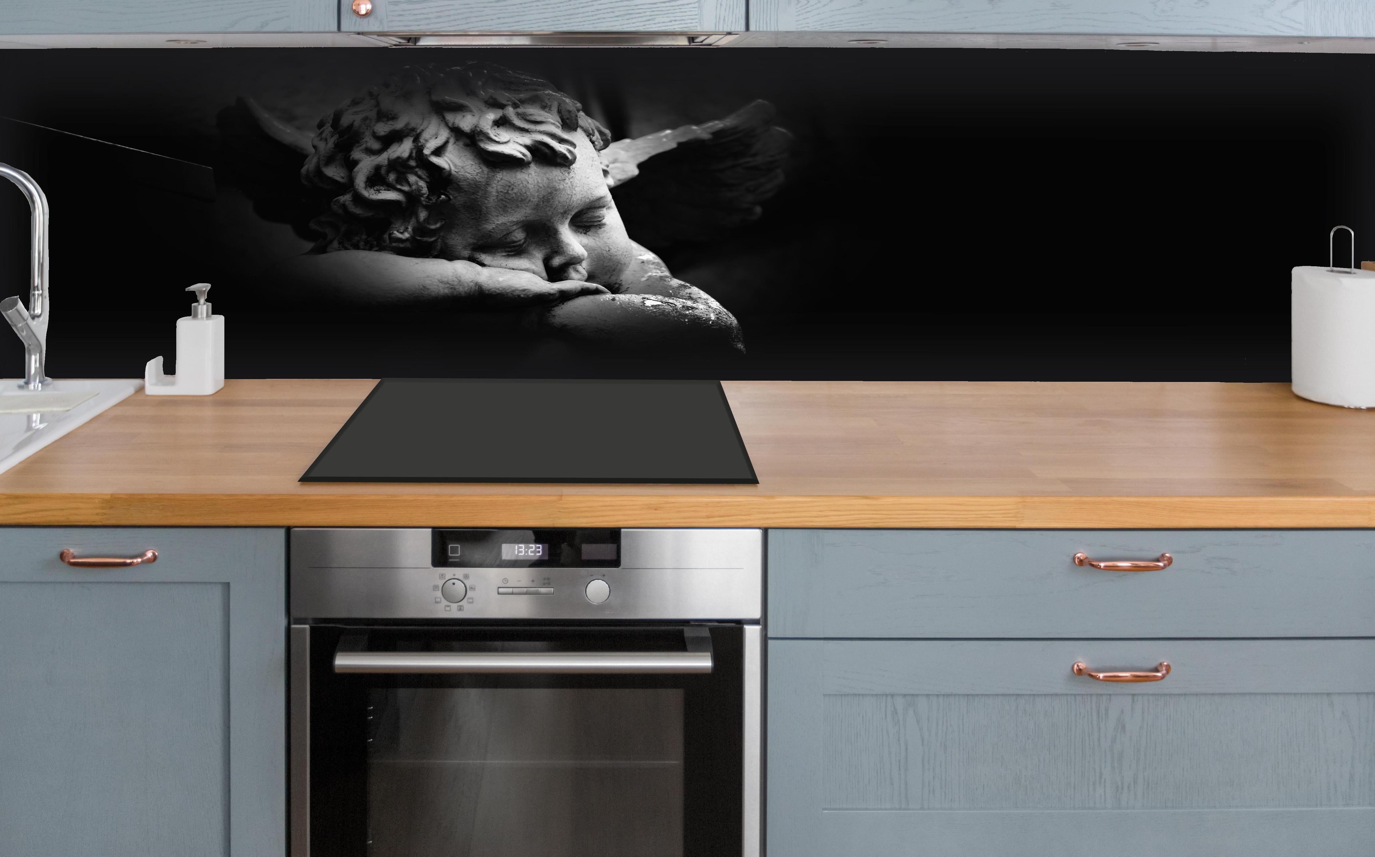 Küche - Schlafender Engel Statue in Schwarz-Weiß hinter weißen Hochglanz-Küchenregalen und schwarzem Wasserhahn