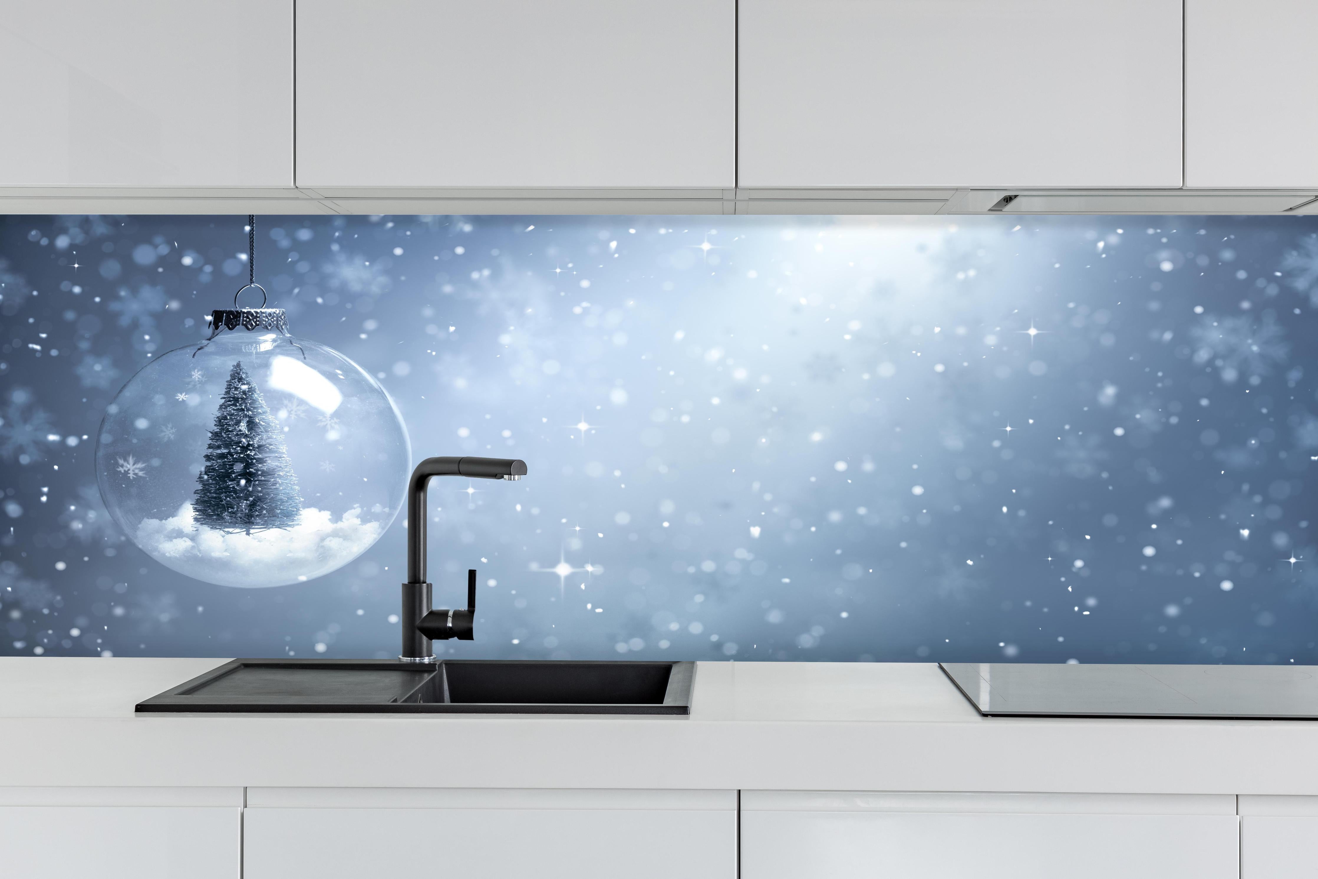 Küche - Schneekugel mit Weihnachtsbaum hinter weißen Hochglanz-Küchenregalen und schwarzem Wasserhahn