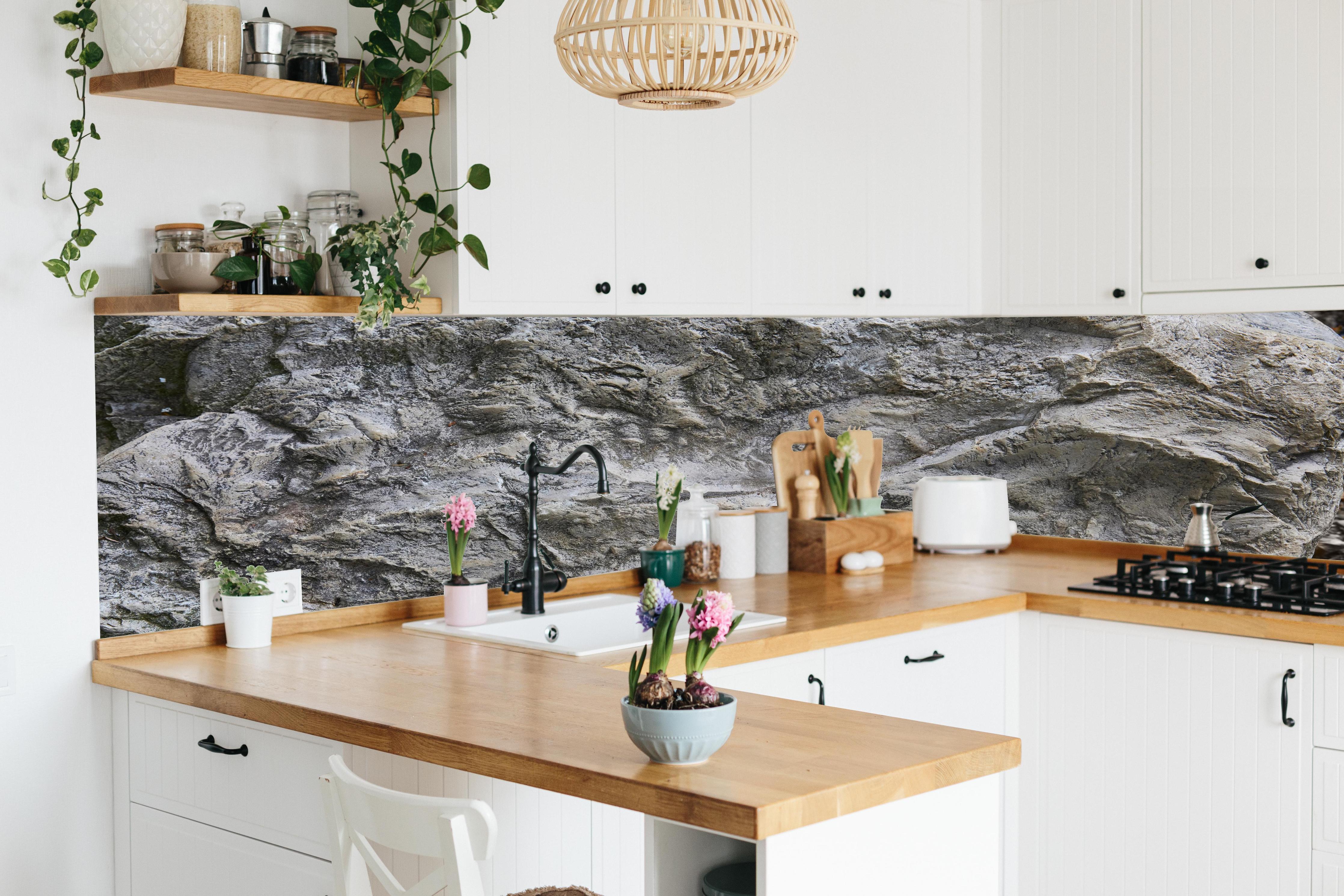 Küche - Schöne Felsstruktur - Granit hinter weißen Hochglanz-Küchenregalen und schwarzem Wasserhahn