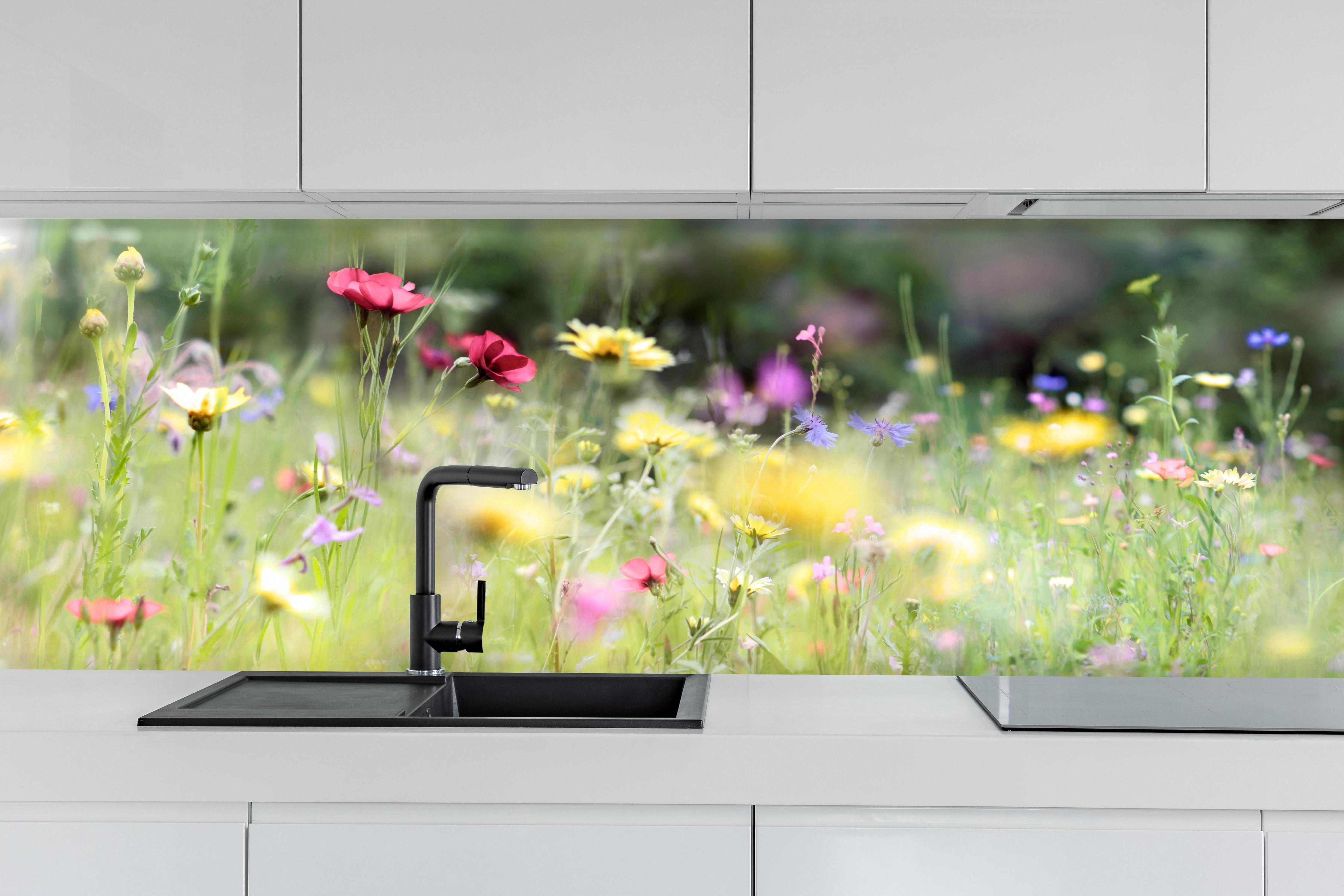 Küche - Schöne Wildblumenwiese hinter weißen Hochglanz-Küchenregalen und schwarzem Wasserhahn