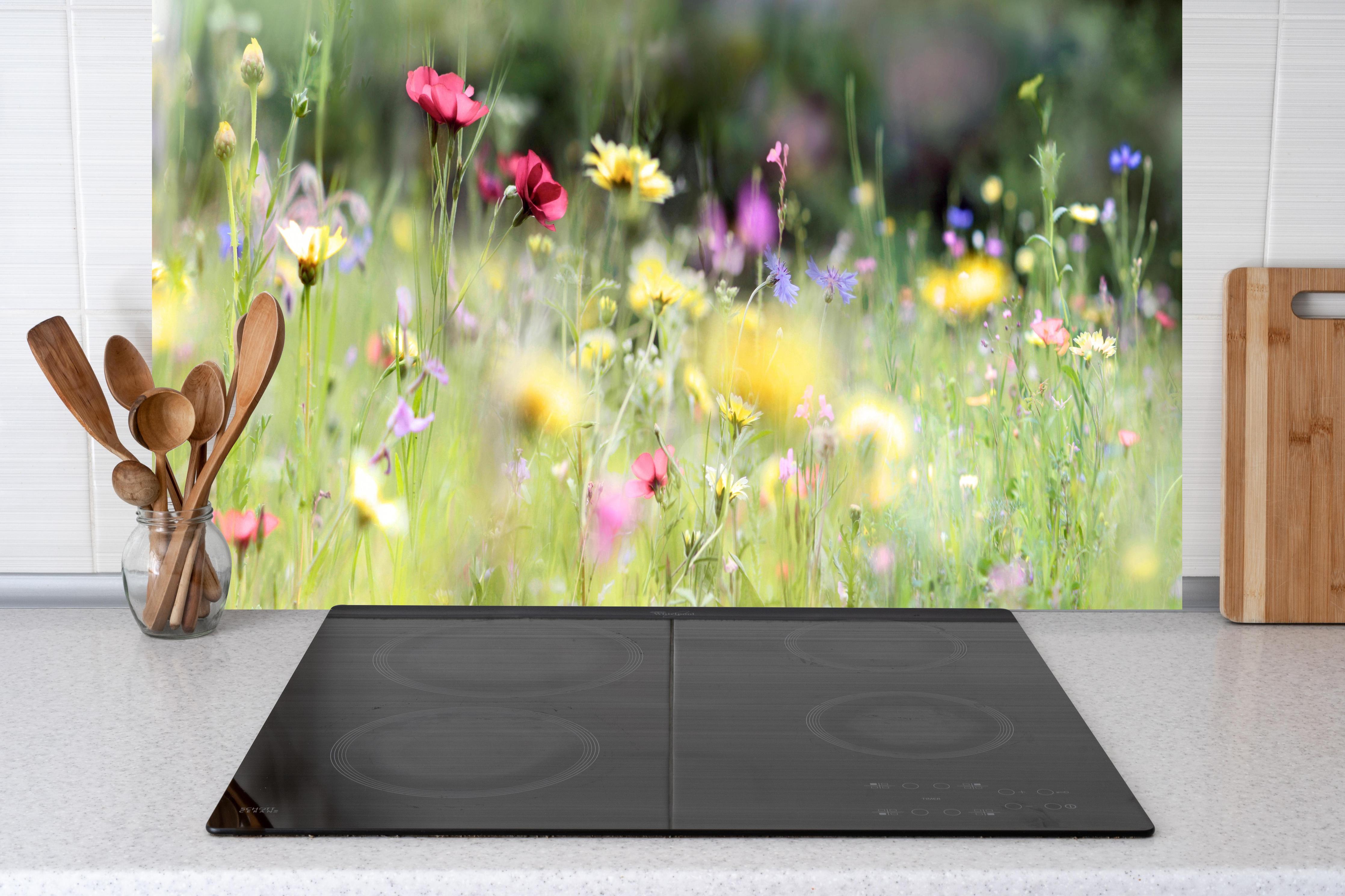 Küche - Schöne Wildblumenwiese hinter weißen Hochglanz-Küchenregalen und schwarzem Wasserhahn