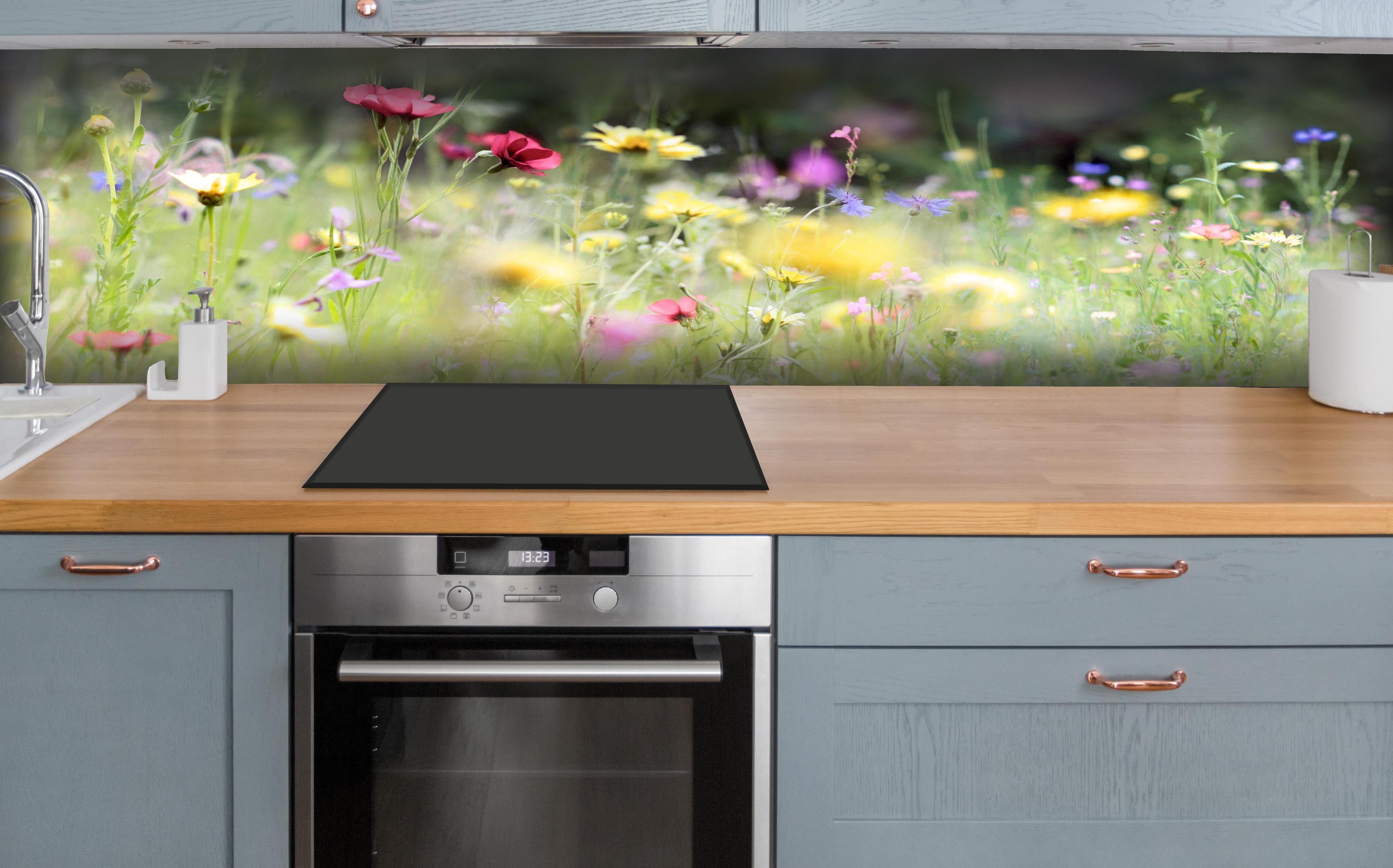 Küche - Schöne Wildblumenwiese hinter weißen Hochglanz-Küchenregalen und schwarzem Wasserhahn