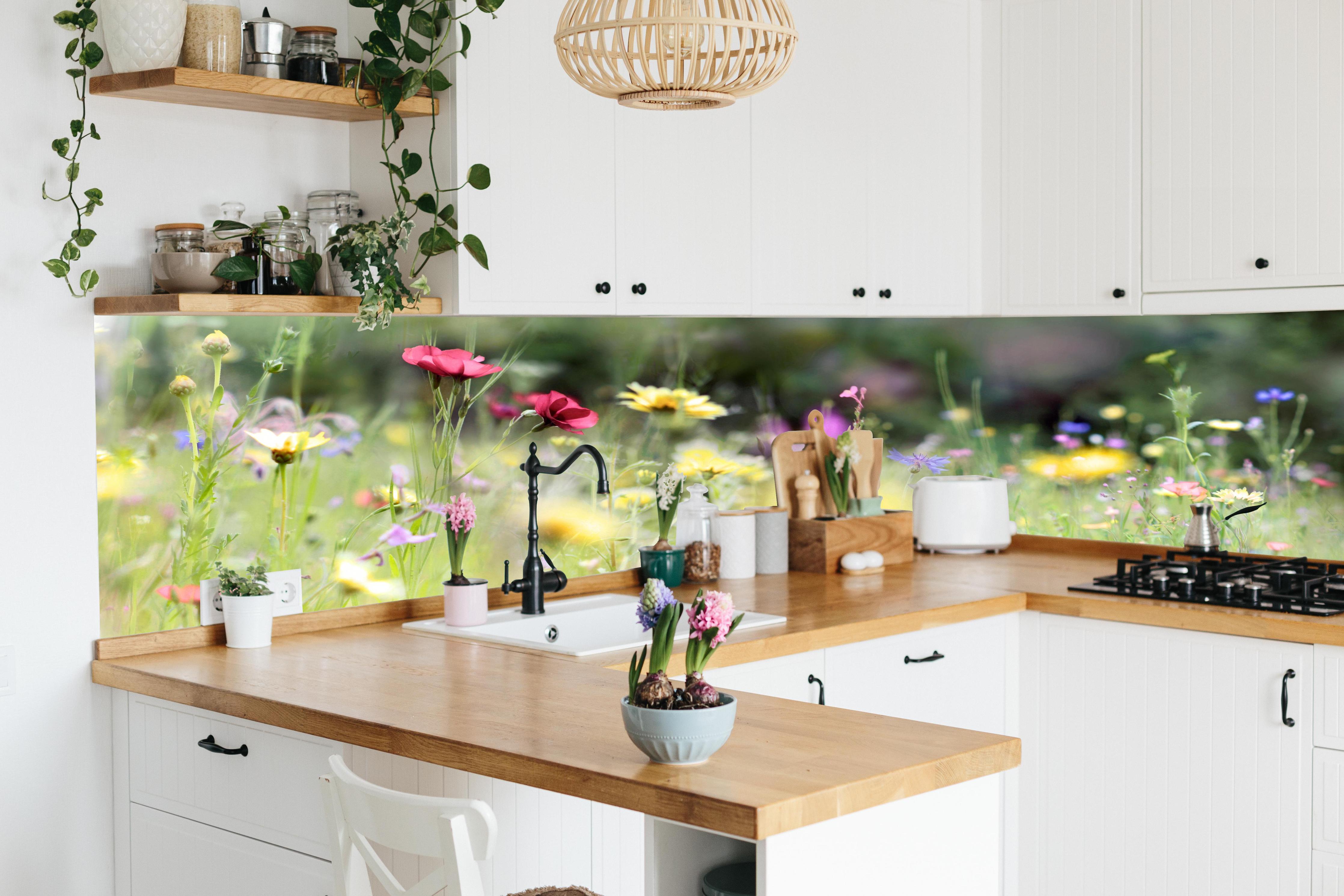 Küche - Schöne Wildblumenwiese hinter weißen Hochglanz-Küchenregalen und schwarzem Wasserhahn