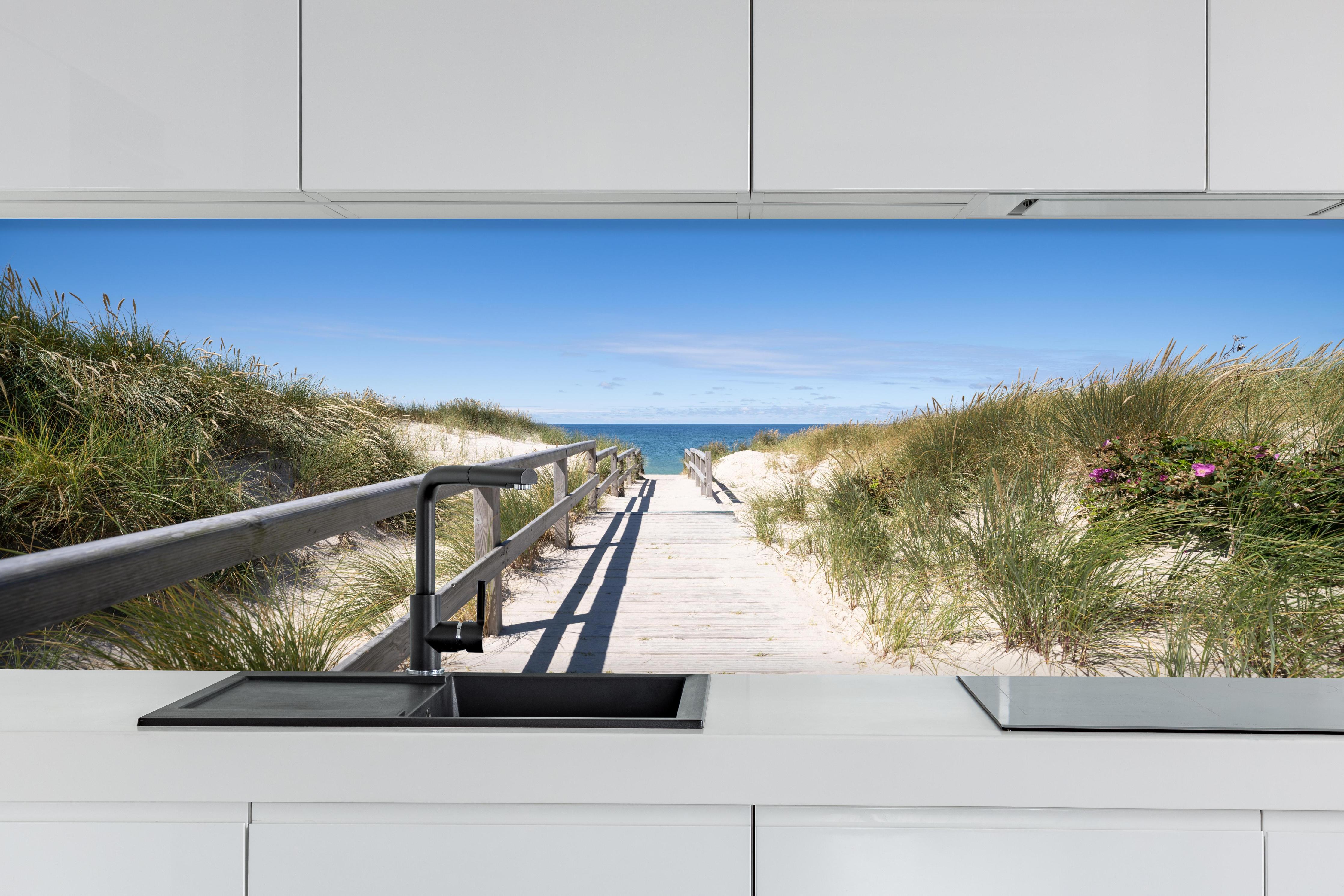 Küche - Schöner Holzsteg zwischen Dünen zum Meer hinter weißen Hochglanz-Küchenregalen und schwarzem Wasserhahn