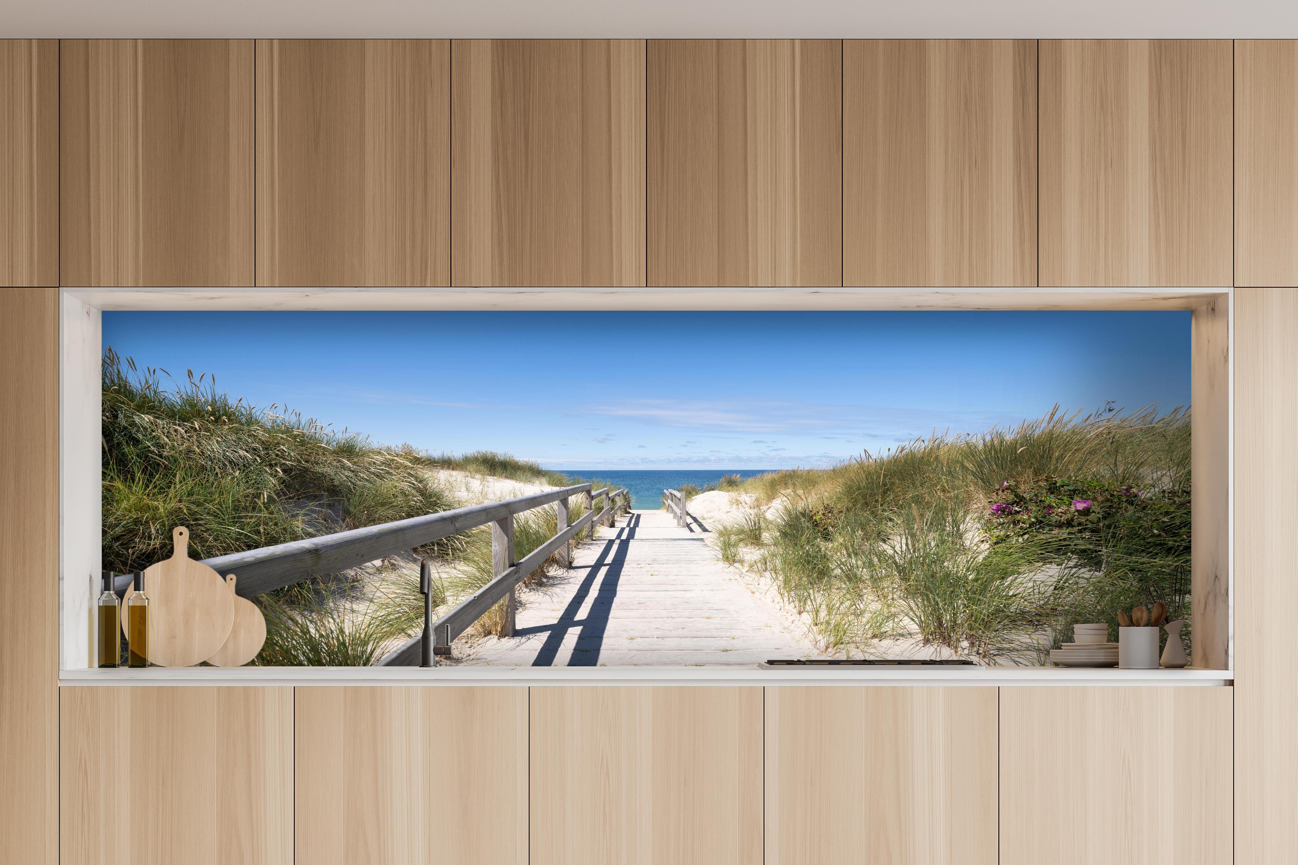 Küche - Schöner Holzsteg zwischen Dünen zum Meer hinter weißen Hochglanz-Küchenregalen und schwarzem Wasserhahn