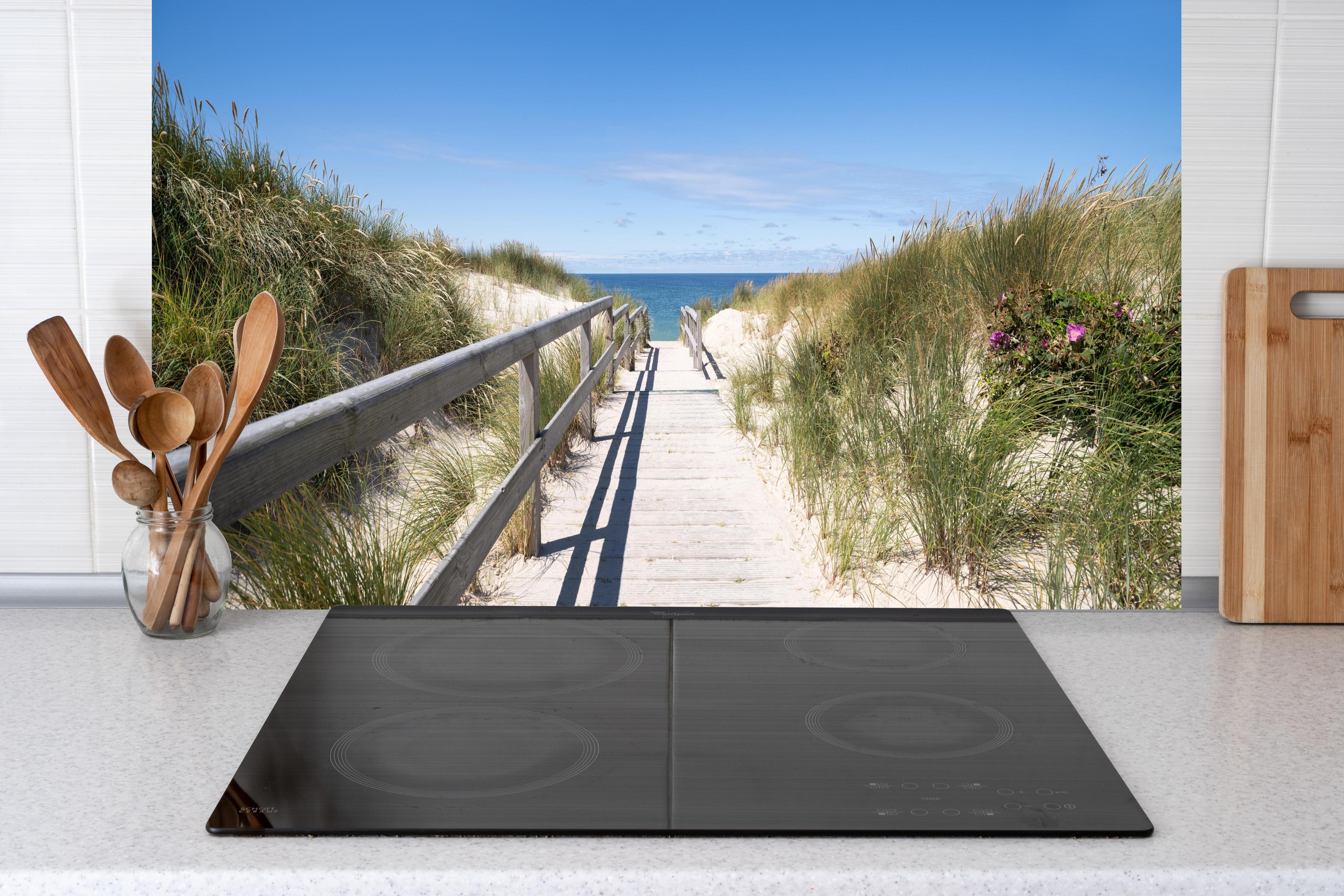 Küche - Schöner Holzsteg zwischen Dünen zum Meer hinter weißen Hochglanz-Küchenregalen und schwarzem Wasserhahn