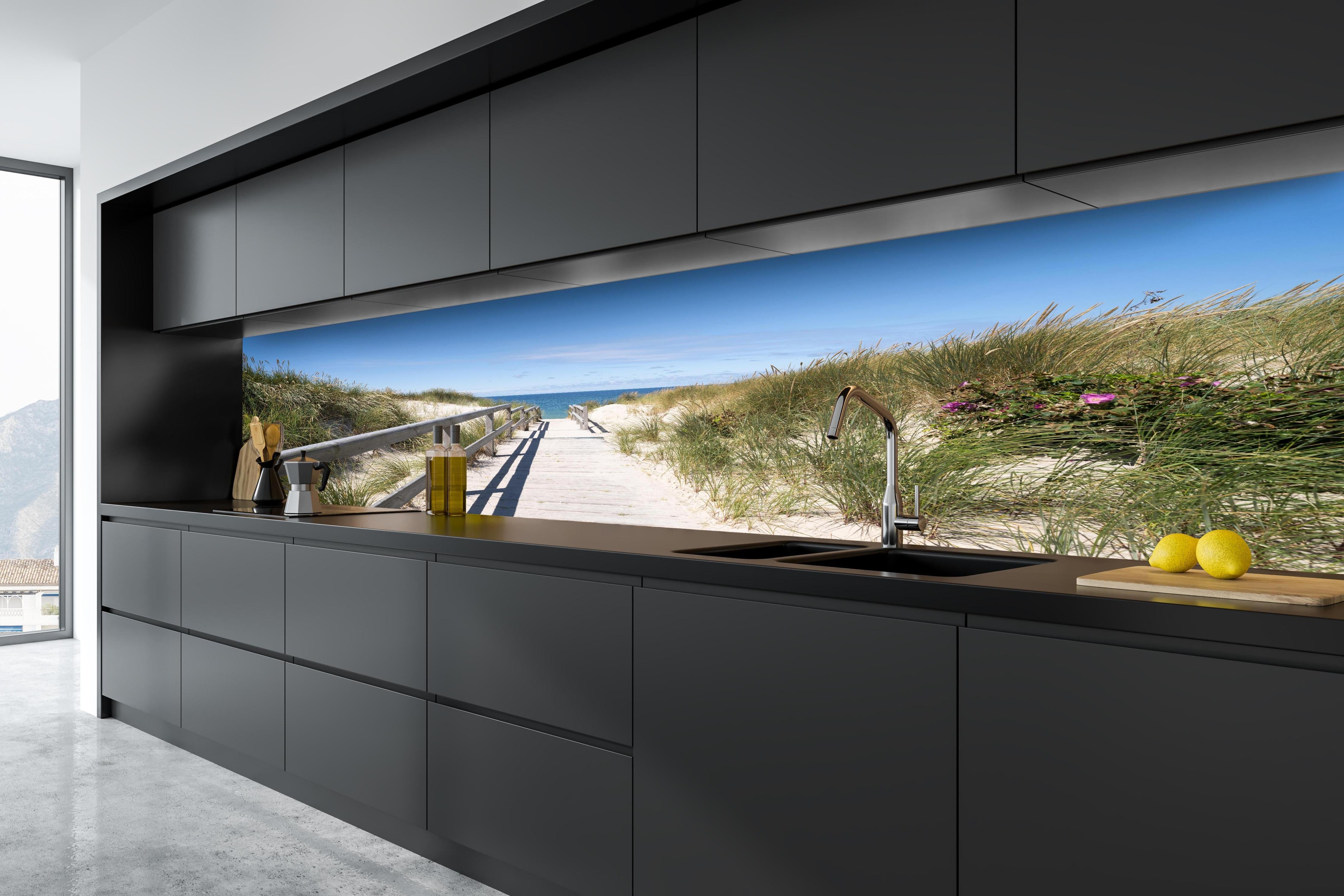 Küche - Schöner Holzsteg zwischen Dünen zum Meer hinter weißen Hochglanz-Küchenregalen und schwarzem Wasserhahn