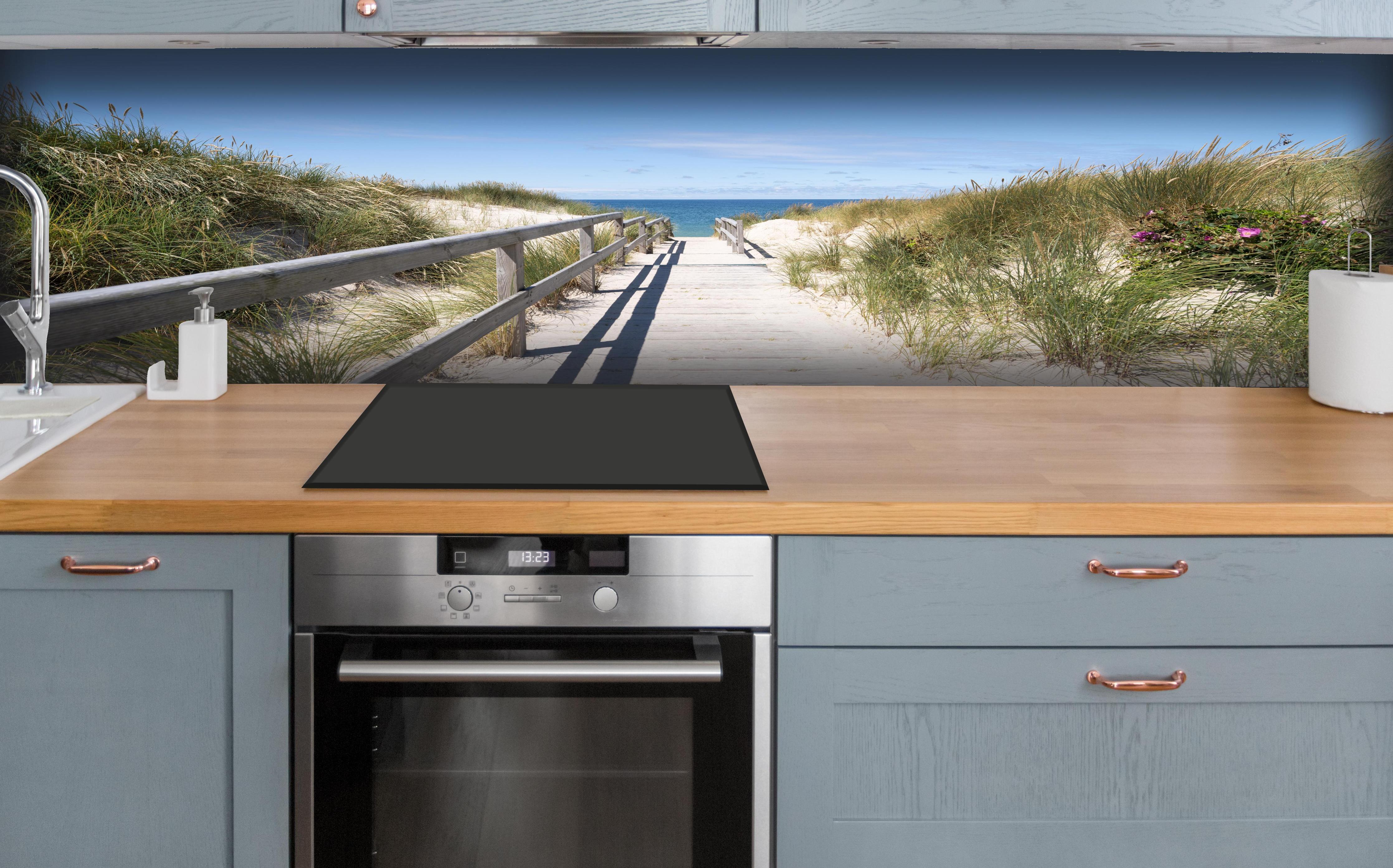 Küche - Schöner Holzsteg zwischen Dünen zum Meer hinter weißen Hochglanz-Küchenregalen und schwarzem Wasserhahn